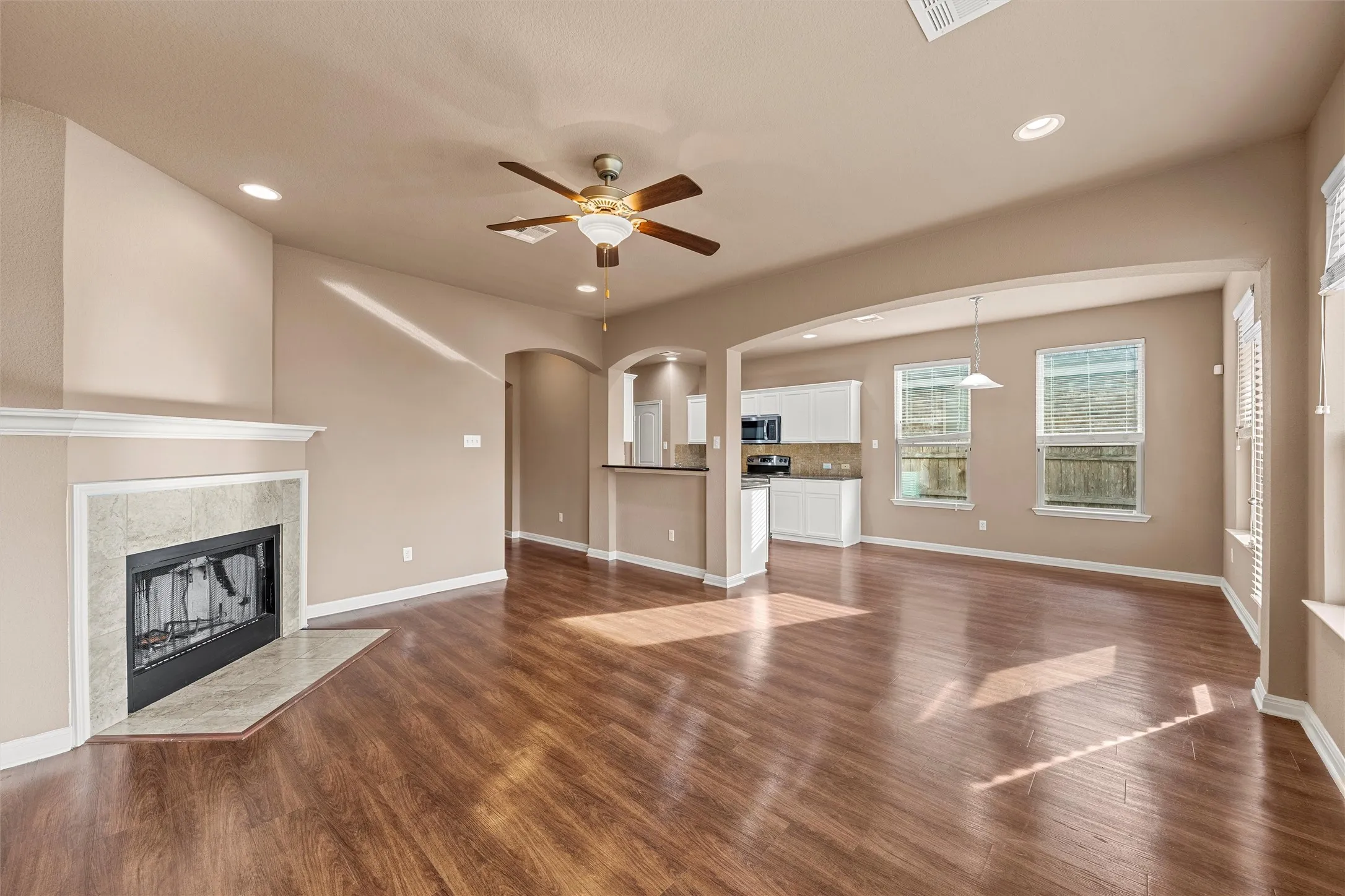 Living area with wood-finish flooring, recessed lighting, and a ceiling fan