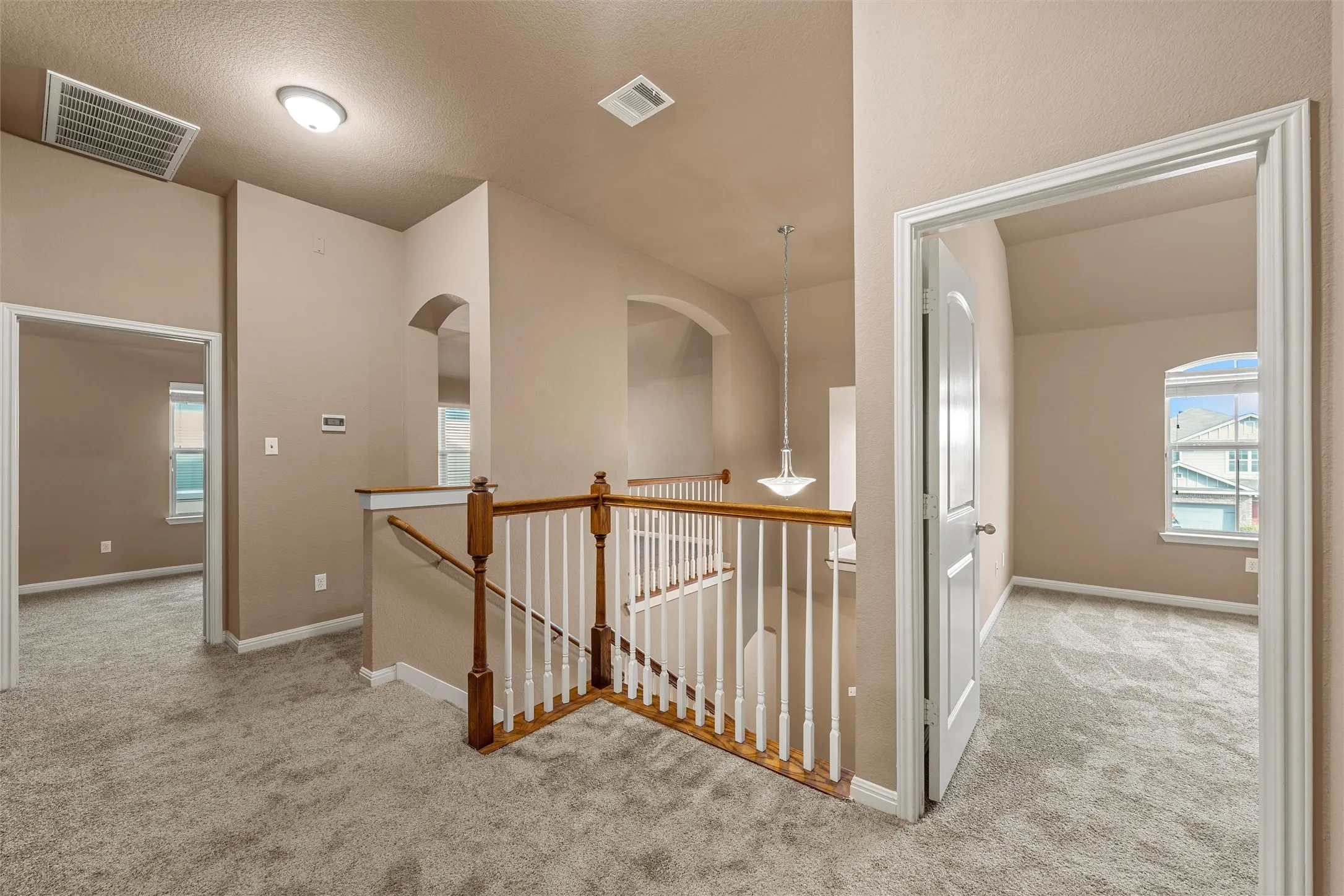 Upper level landing featuring carpet flooring and a wood baluster railing