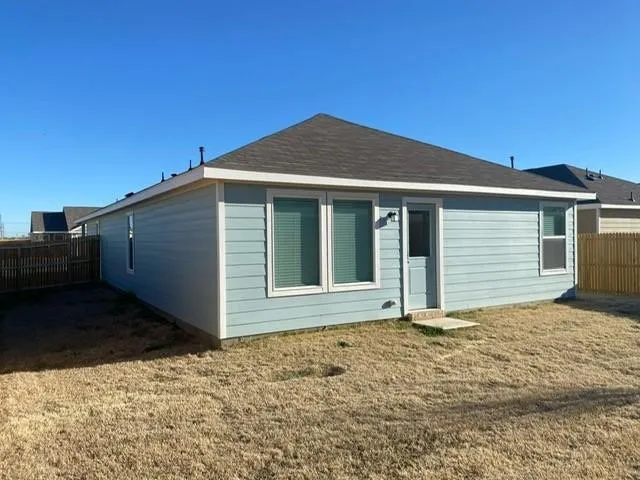 Light blue horizontal siding and a dark shingle roof