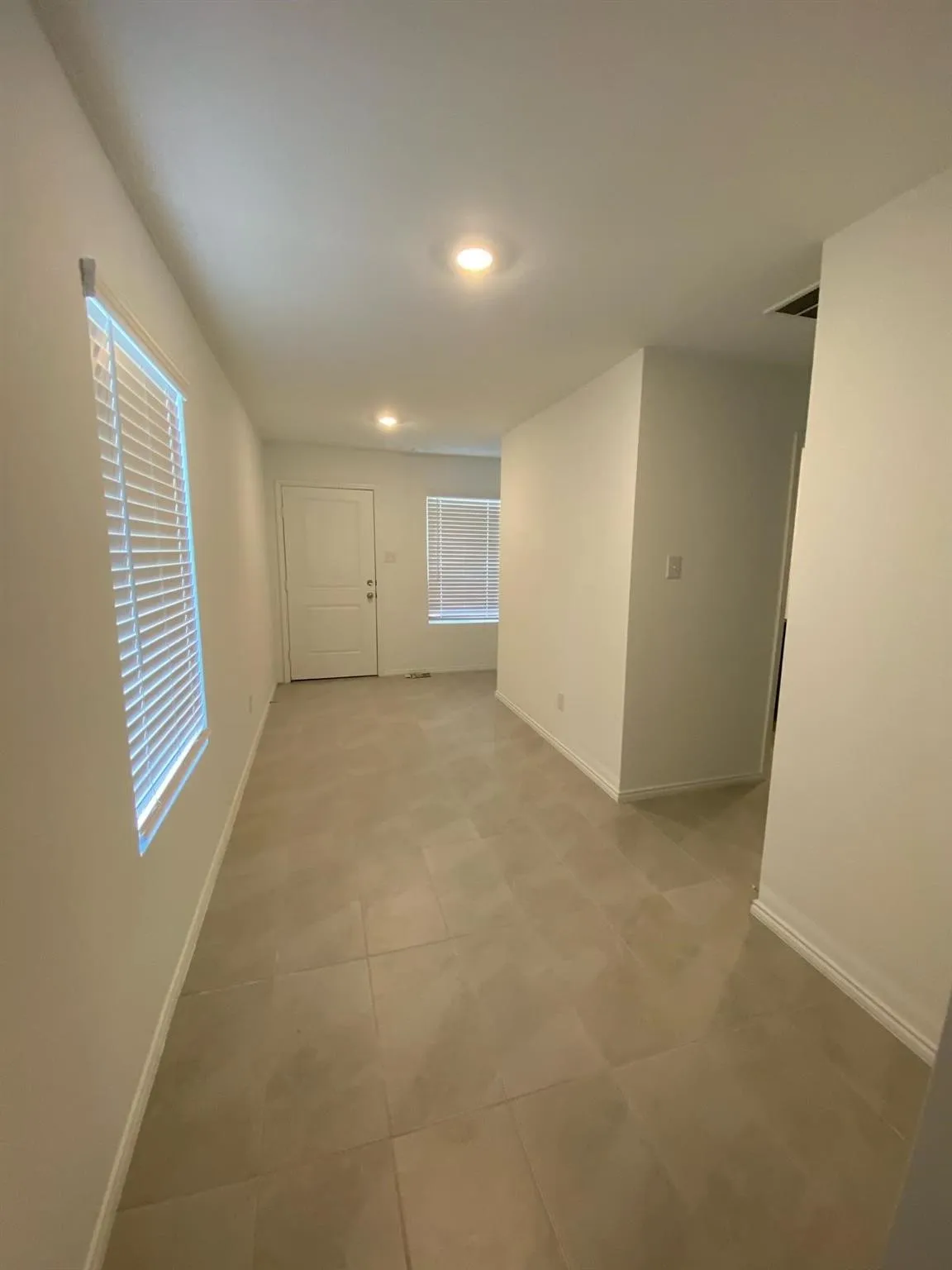 Recessed lighting, tile flooring, and neutral wall tones