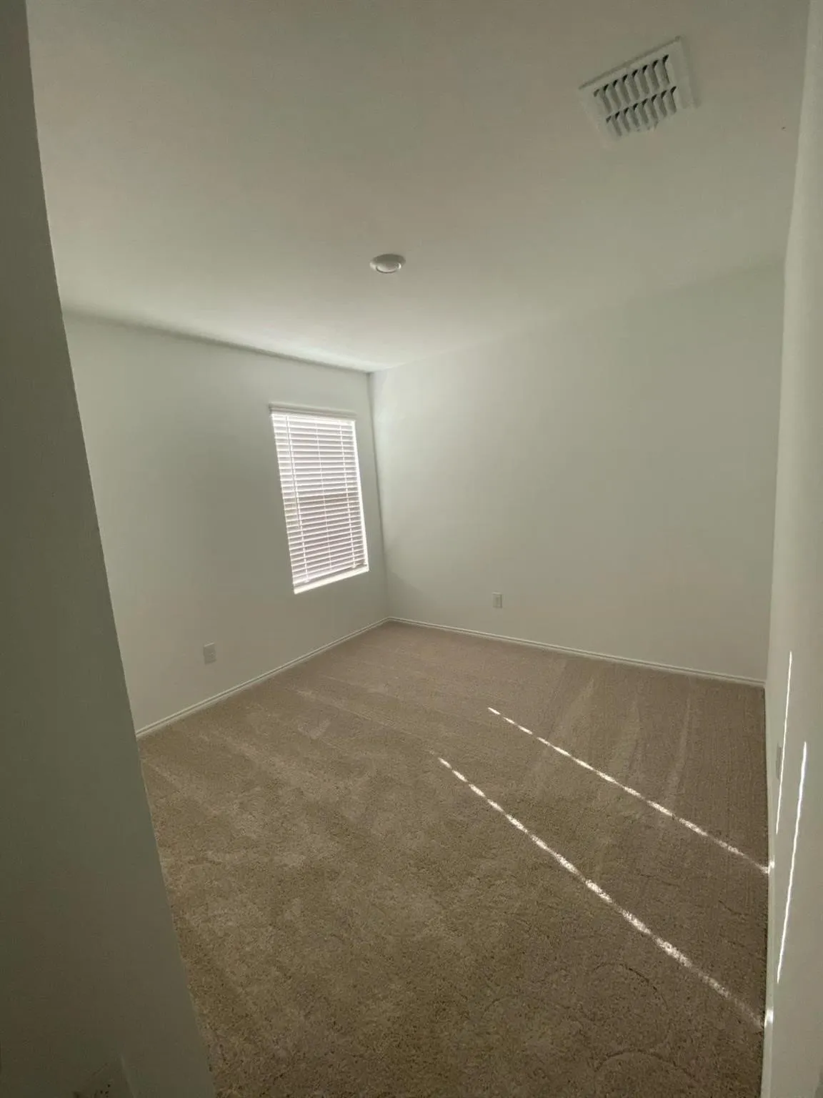 Recessed lighting, neutral-toned carpeting, window with horizontal blinds, and white wall finishes