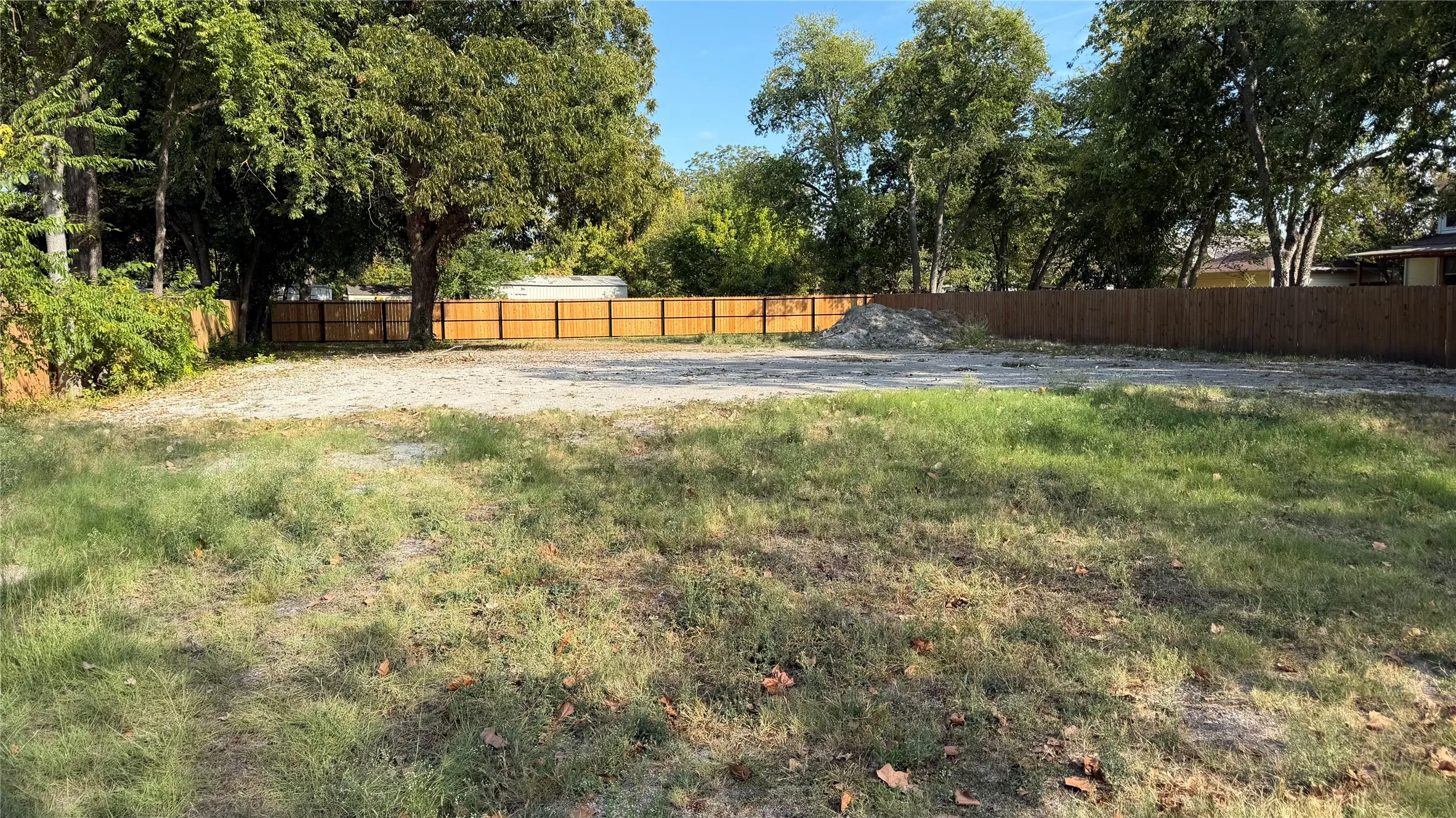 Expansive lot with mature trees and perimeter fencing