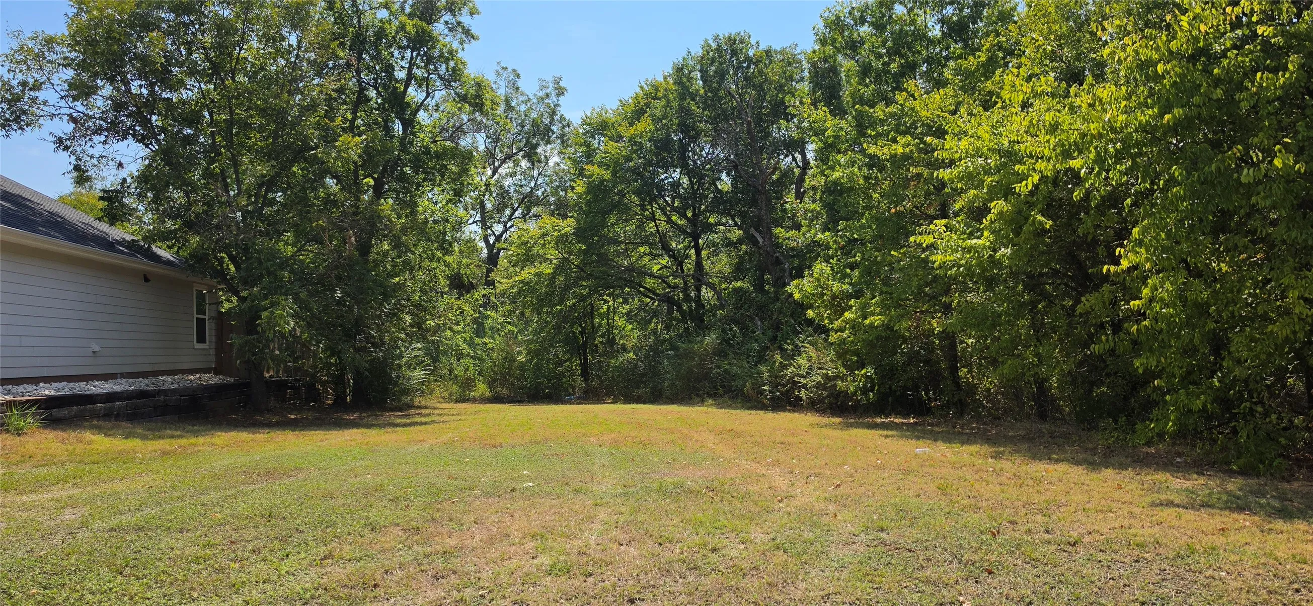 Expansive yard with natural tree line and mature foliage