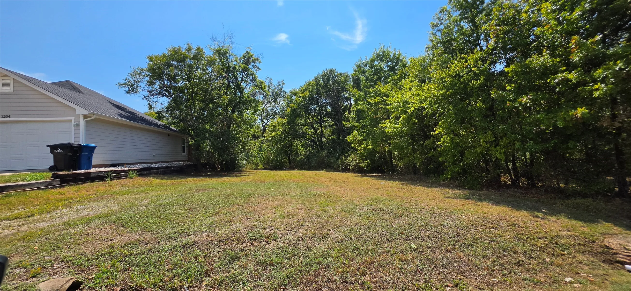 Expansive lot featuring a large grassy area and mature trees