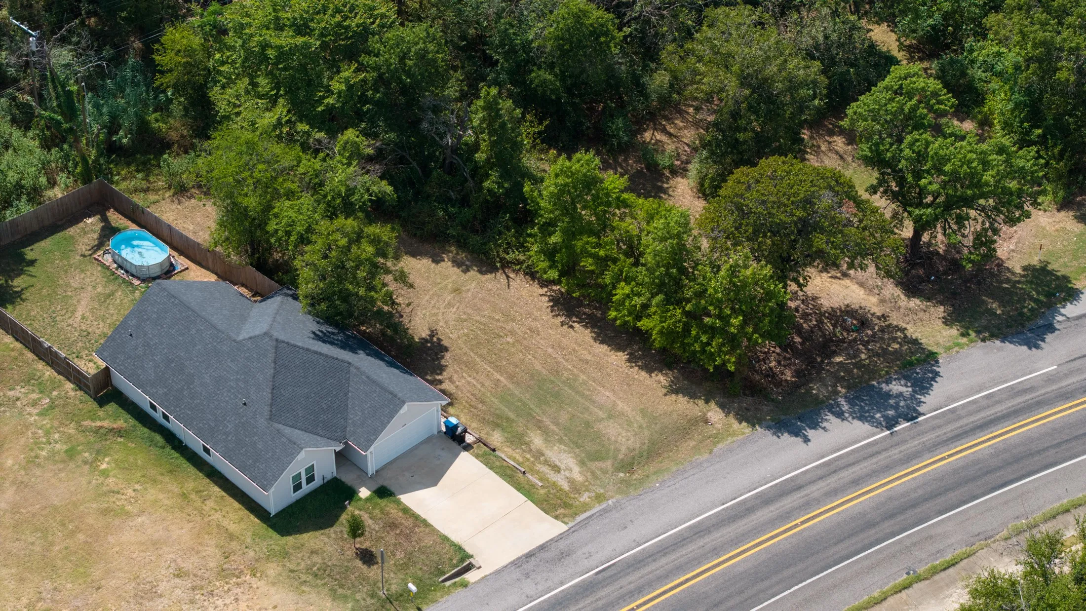 Single-story residence with an attached garage, a dark shingle roof, and a concrete driveway