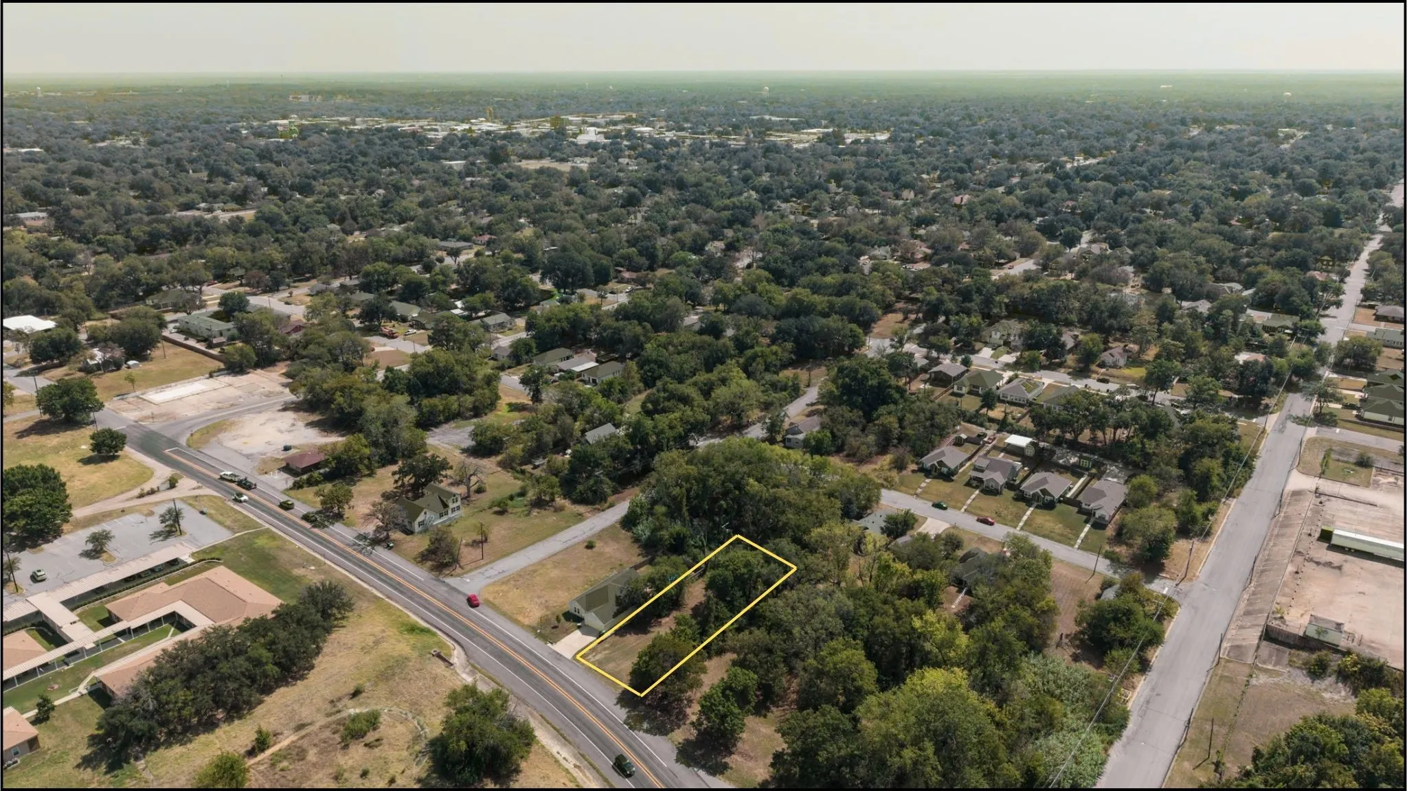 Expansive land parcel with surrounding established homes and mature trees