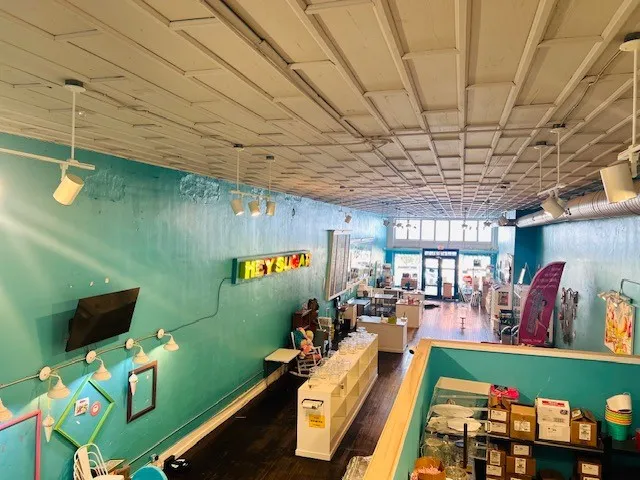 Expansive interior space featuring a grid panel ceiling and exposed ductwork