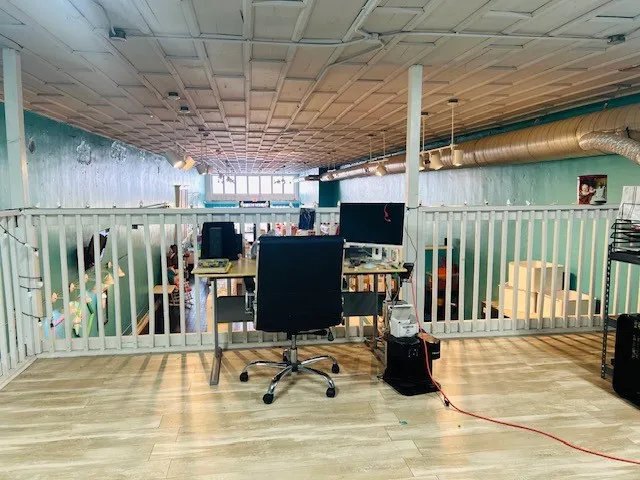 Upper-level area featuring wood-finish flooring, white railing, and an exposed ceiling with recessed lighting