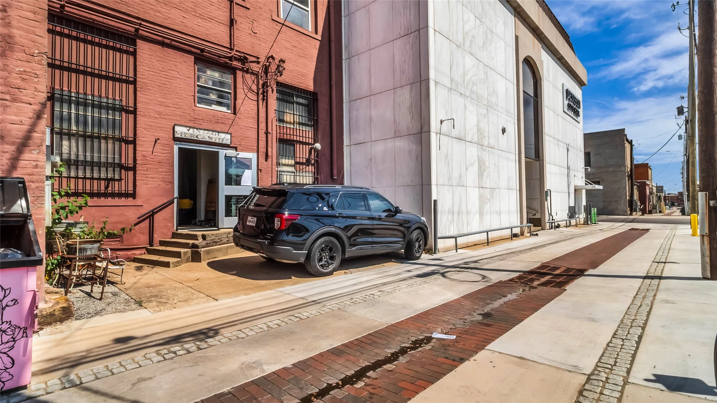 Red brick building facade with multiple windows featuring security bars