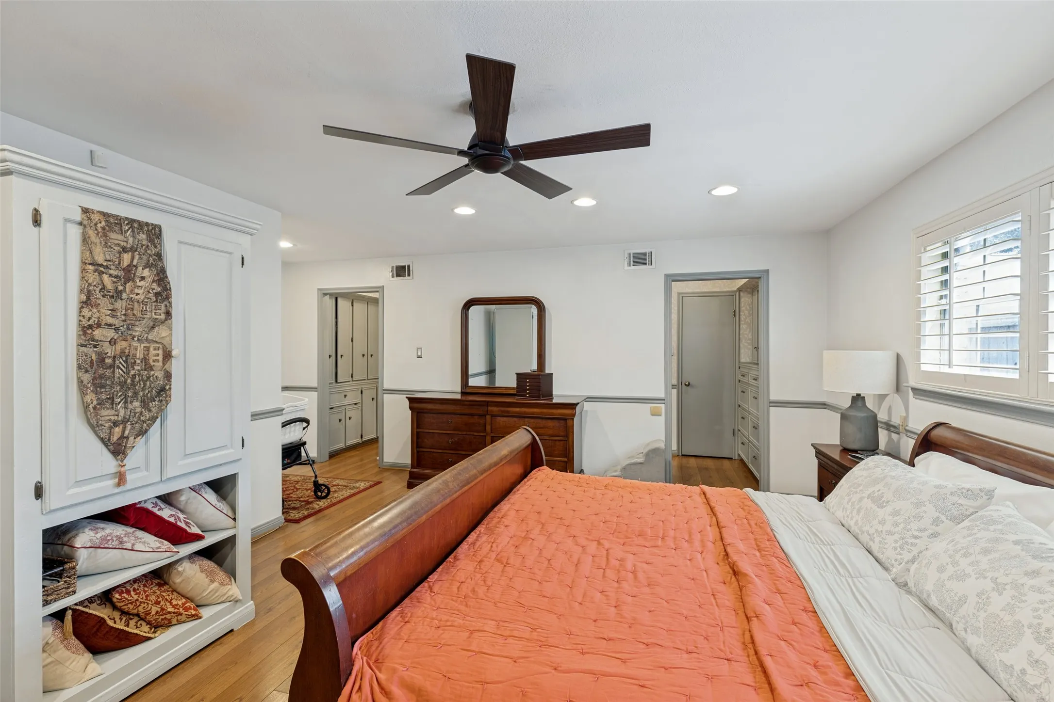 Recessed lighting, wood-finish flooring, ceiling fan, and white plantation shutters