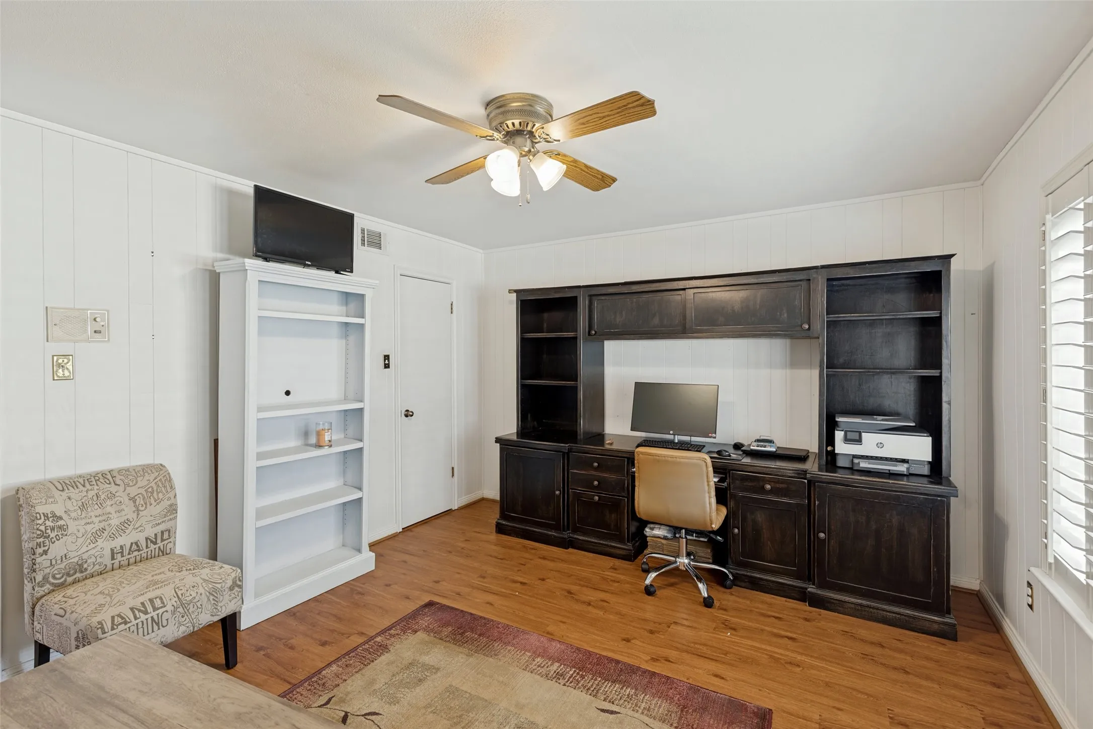 Wood-finish flooring with white paneled walls