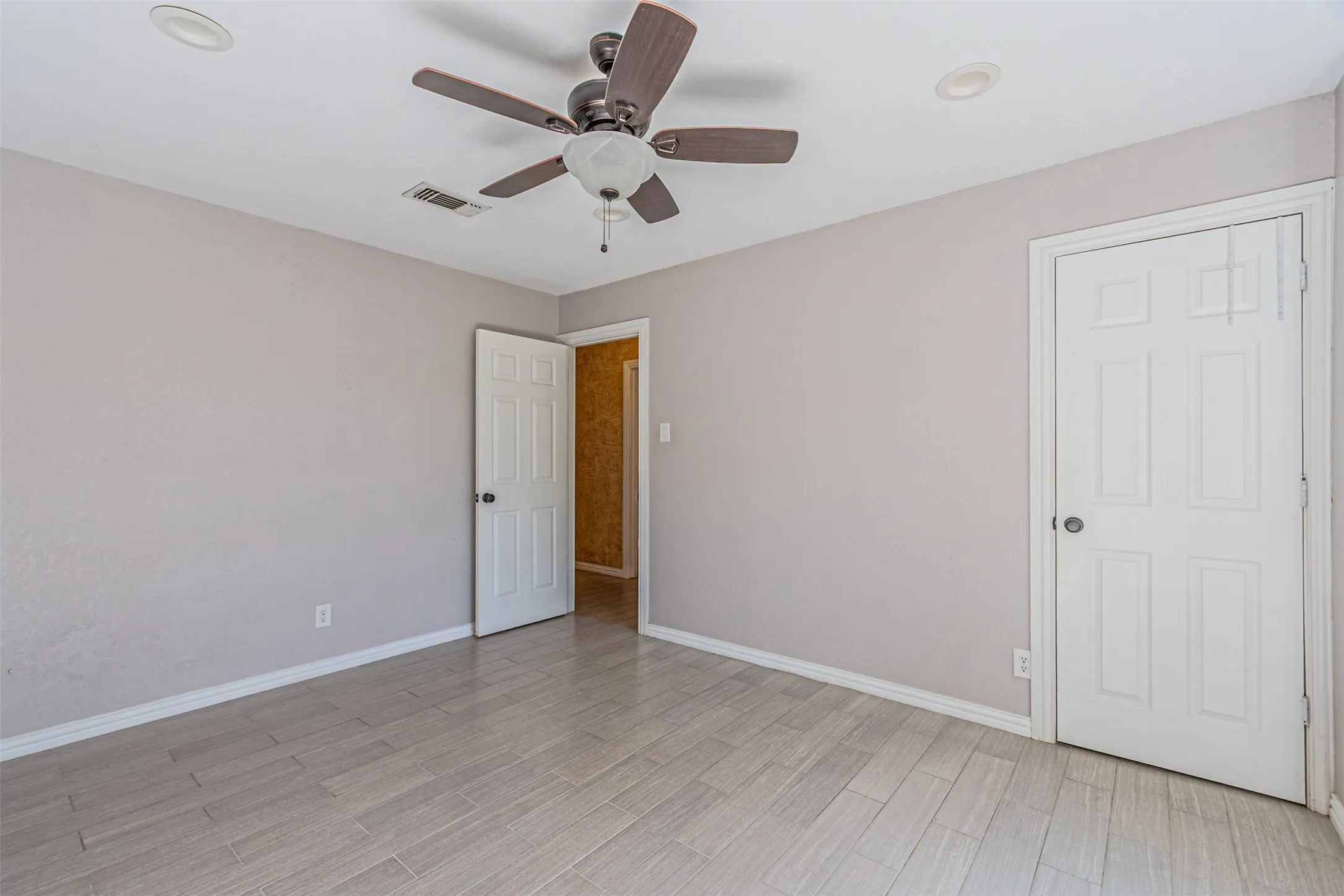Ceramic plank-style flooring, a ceiling fan with integrated lighting, and recessed ceiling lights