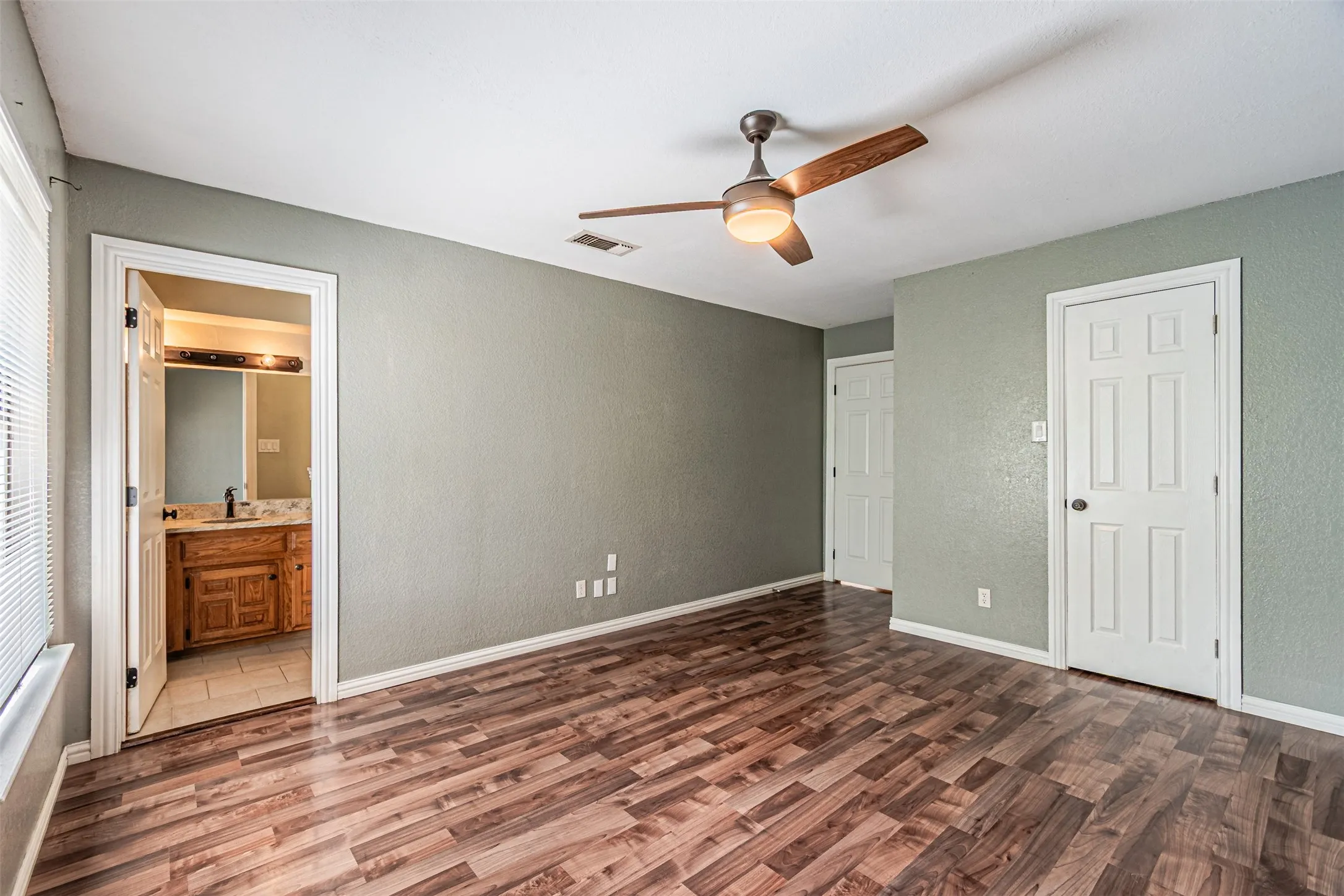 Wood-finish flooring with a ceiling fan with light fixture