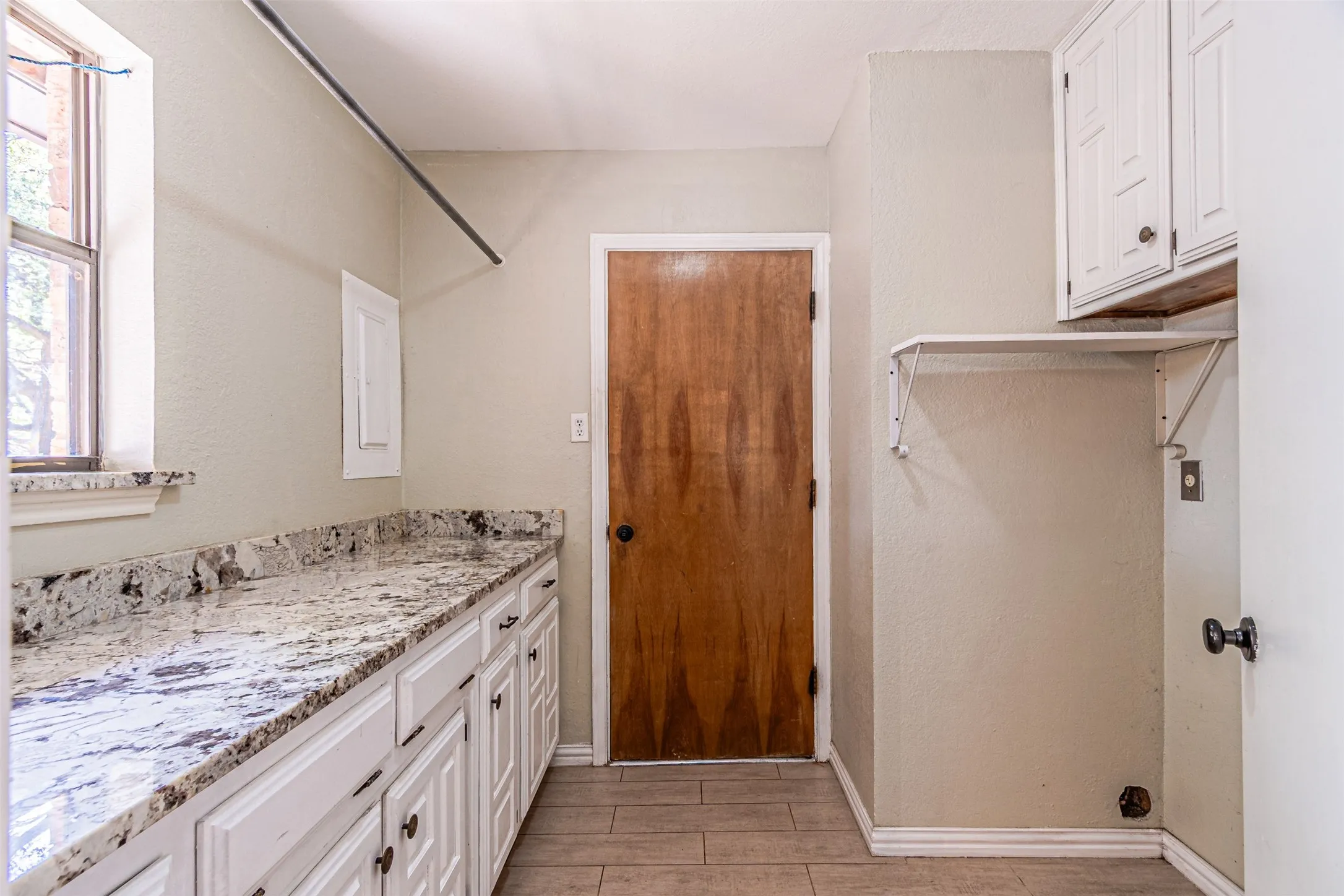 Extensive countertop space, white cabinetry, built-in upper cabinets, and tile flooring