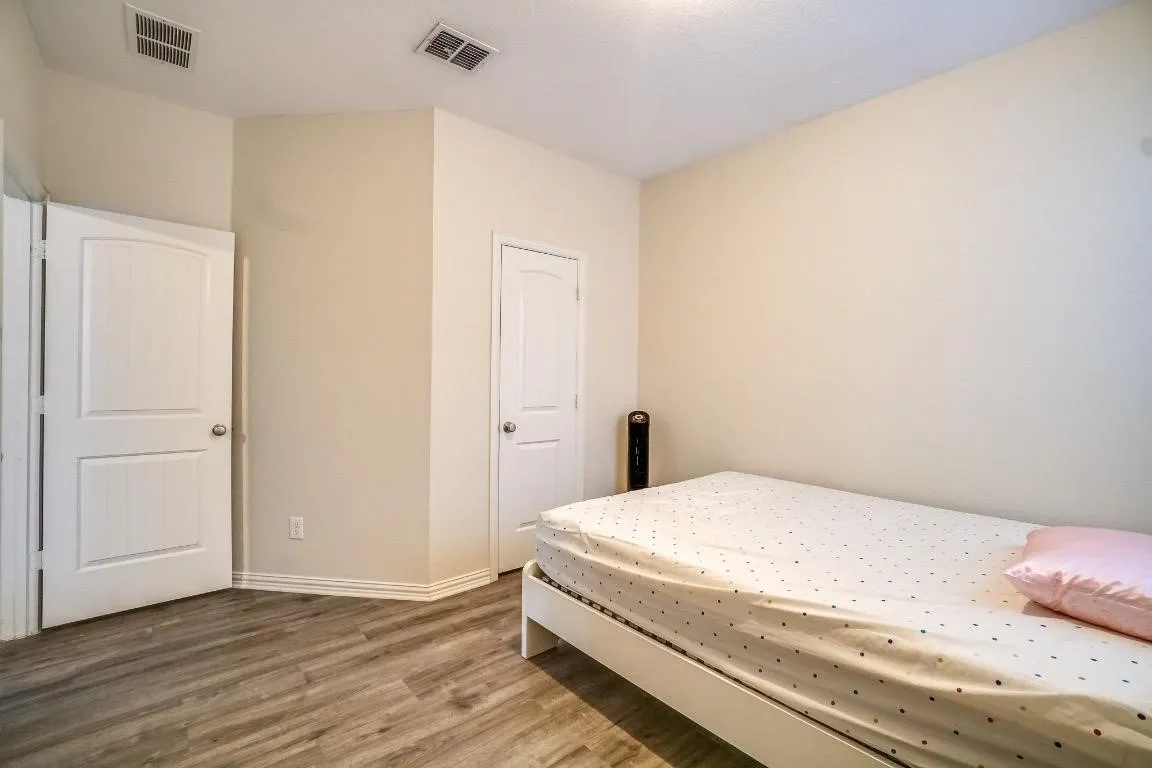 Wood-finish flooring with neutral wall tones, white trim, and white paneled doors