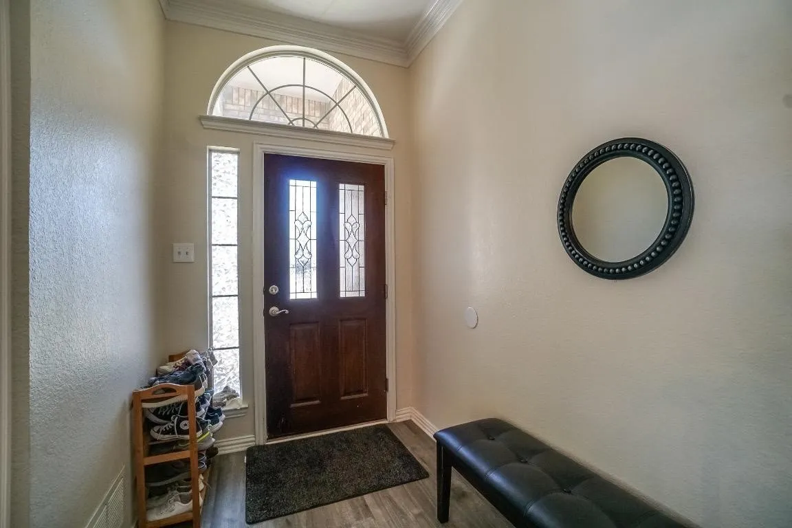 Hardwood entry door with decorative glass inserts and an arched transom window