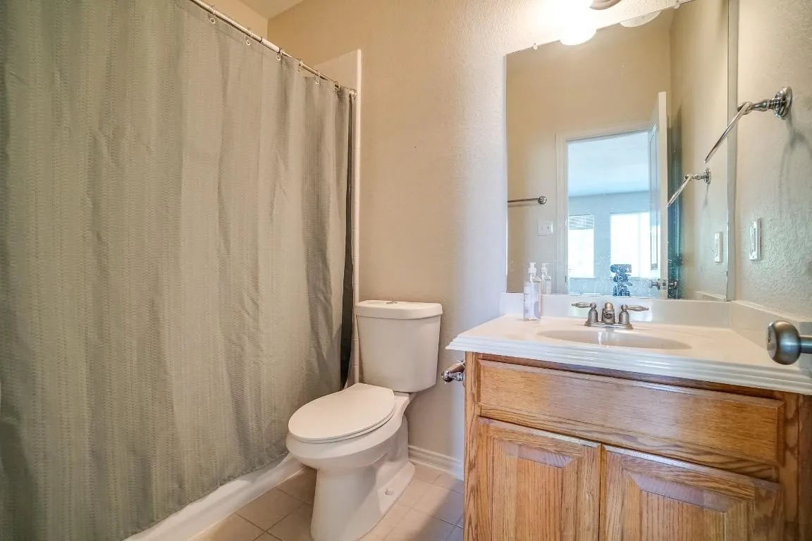 Vanity with wood-finish cabinetry, integrated sink, and brushed nickel faucet