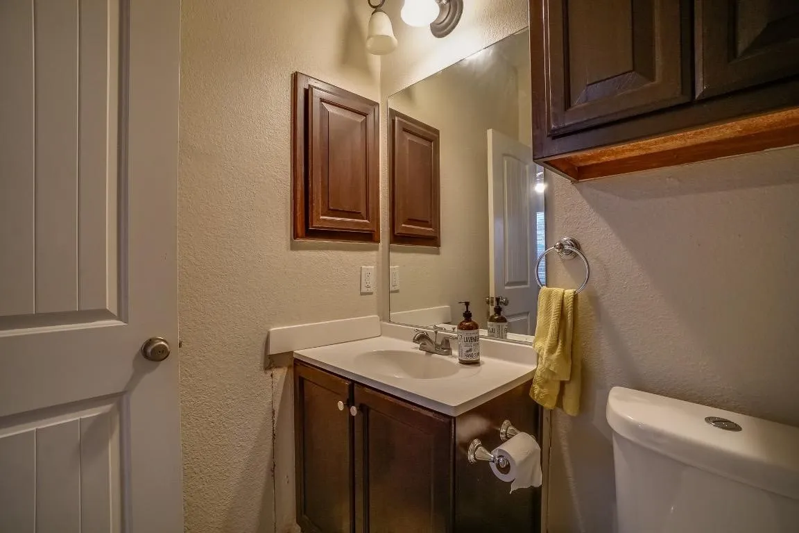 Vanity with an integrated sink, polished chrome faucet, and dark wood-finish cabinetry