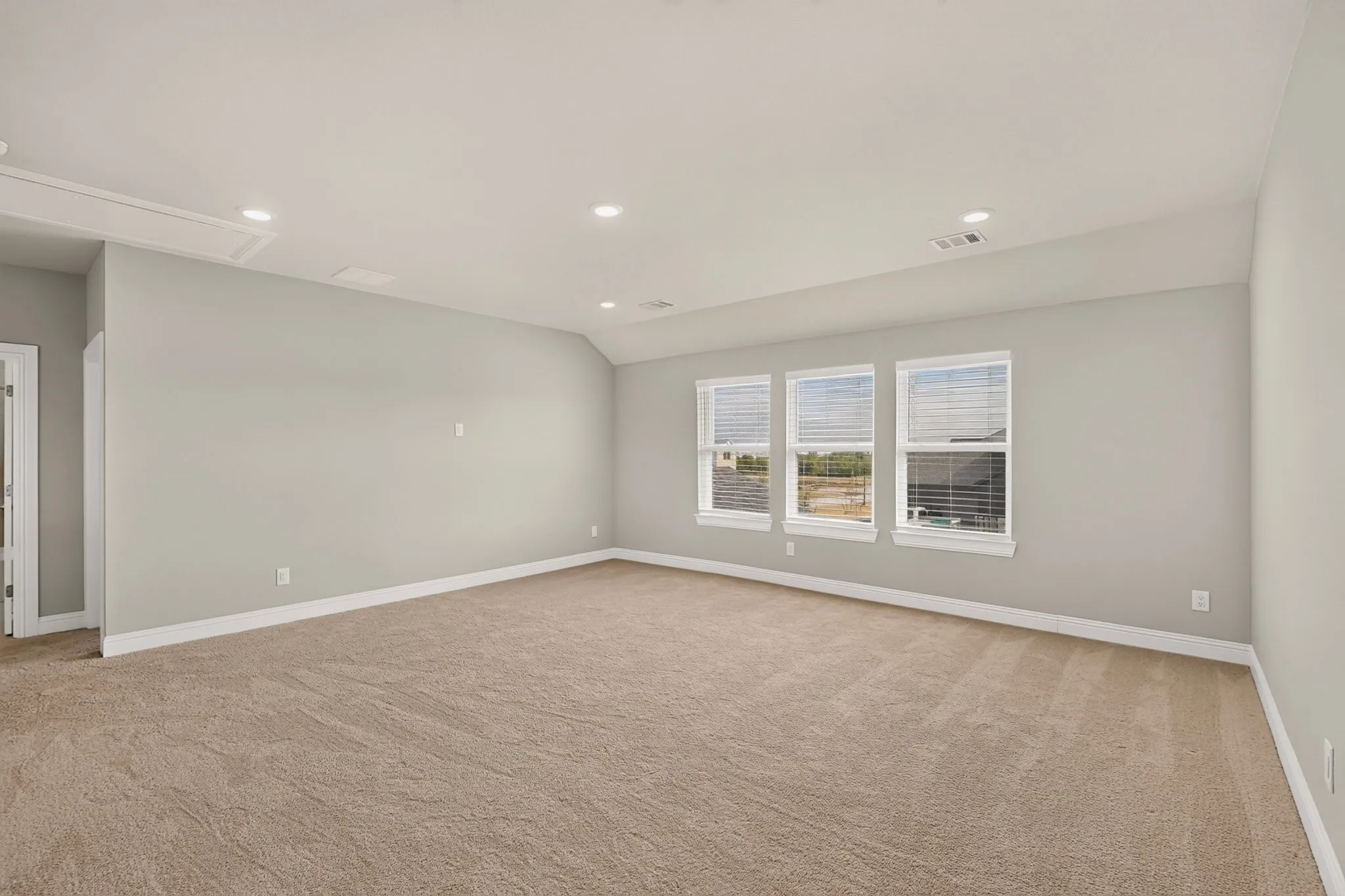 Recessed lighting, light-colored walls, carpeted flooring, and multiple windows with blinds