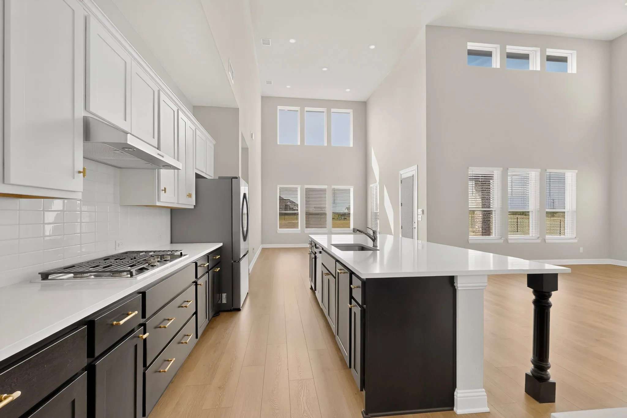 Kitchen featuring two-tone cabinetry, a gas cooktop, and a deep basin sink
