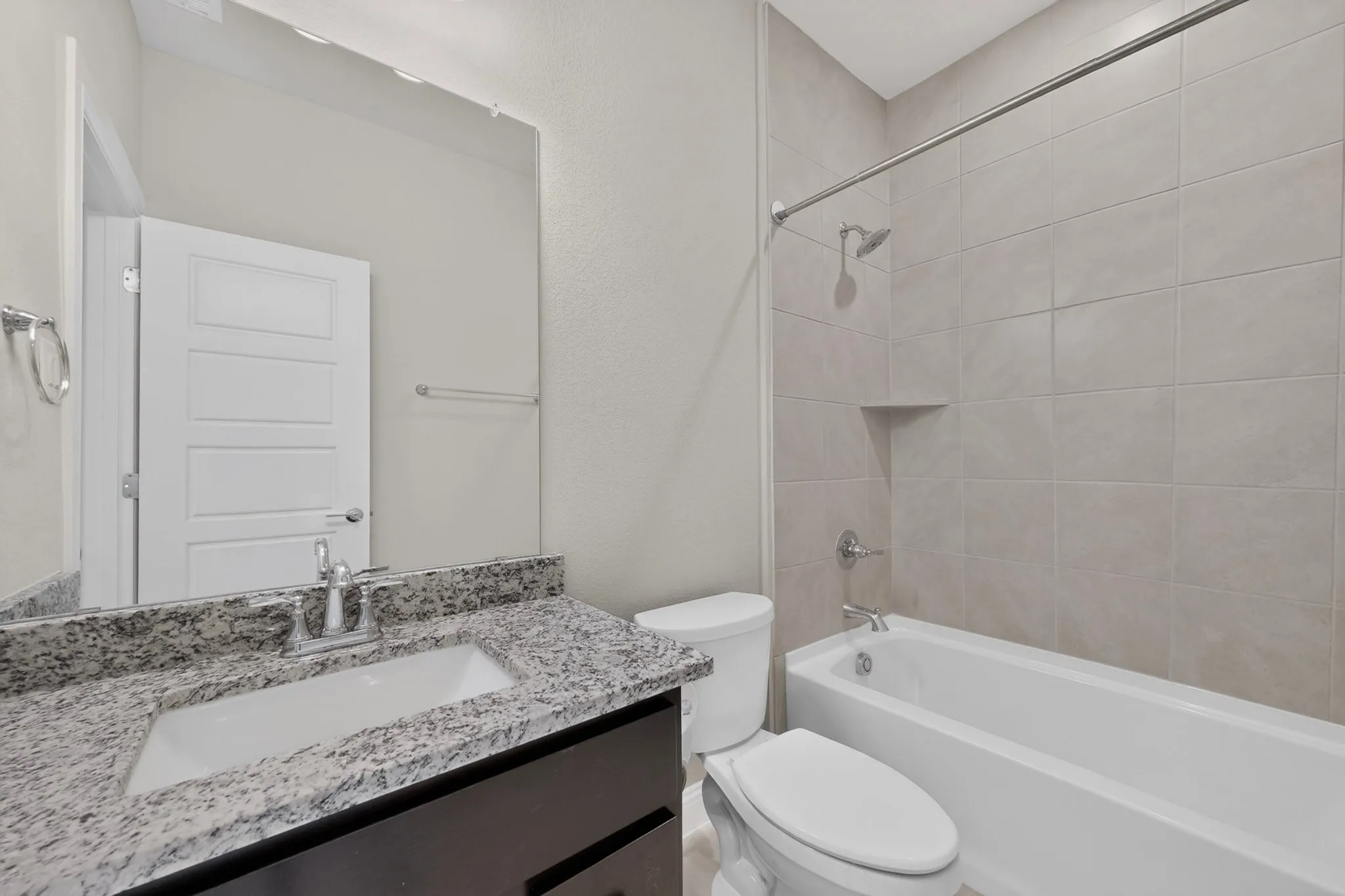 Bathroom featuring a vanity with a granite countertop, undermount sink, and chrome fixtures