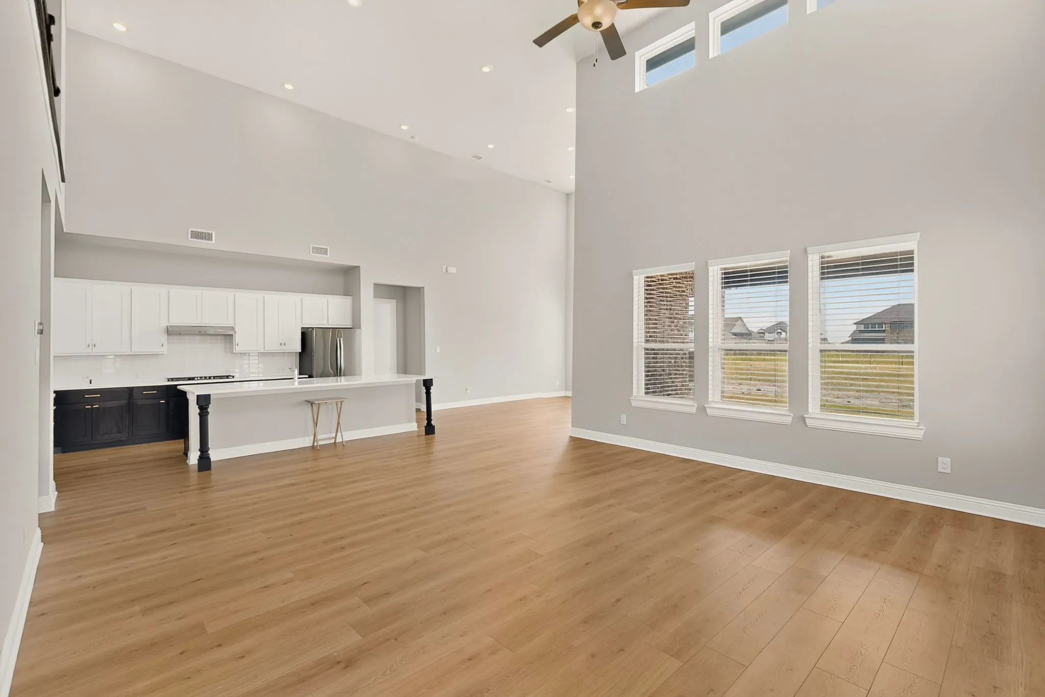 Vaulted ceilings with recessed lighting, wood-finish flooring, and multiple transom windows