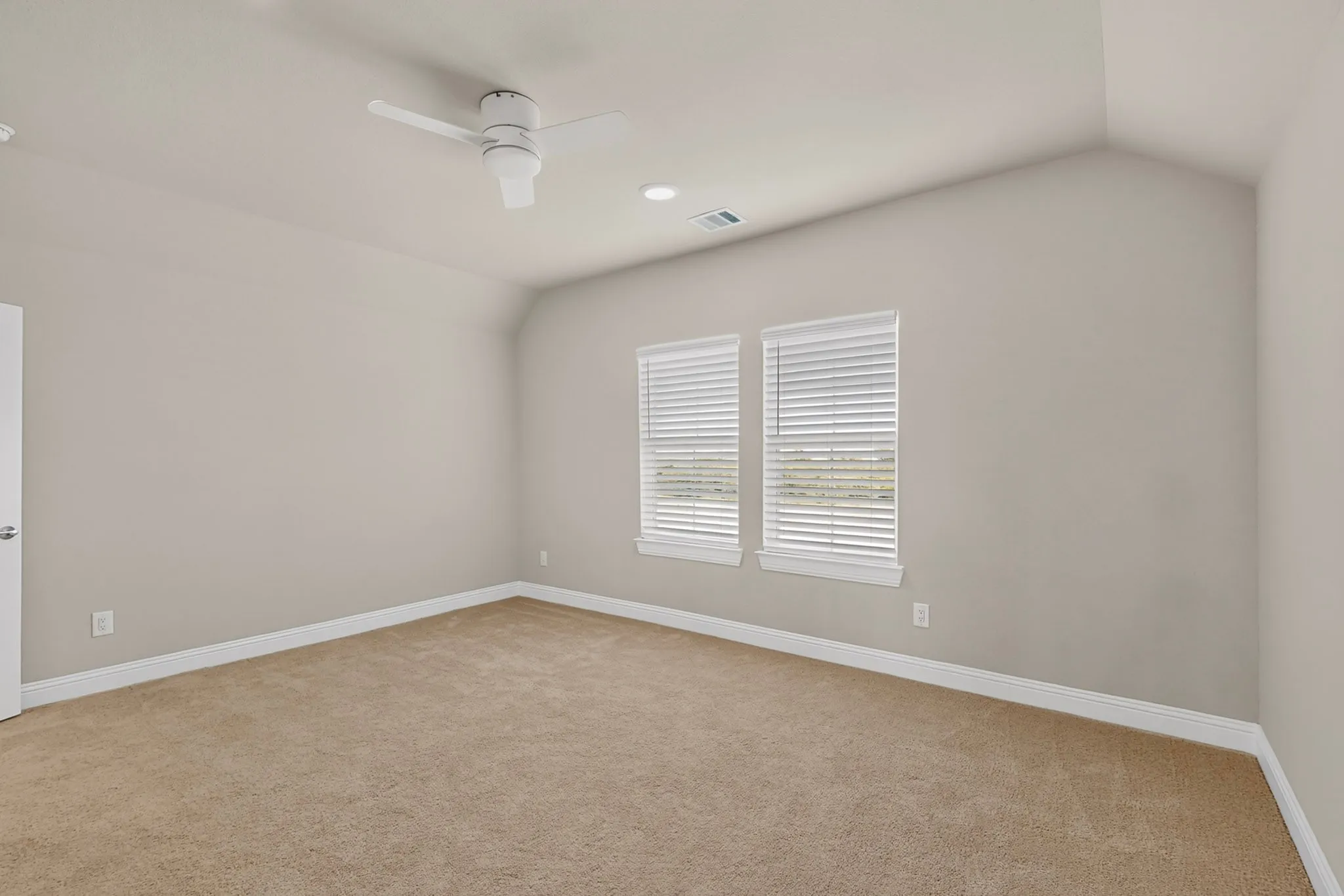 Vaulted ceiling, two windows with blinds, recessed lighting, ceiling fan, and neutral-toned carpeting