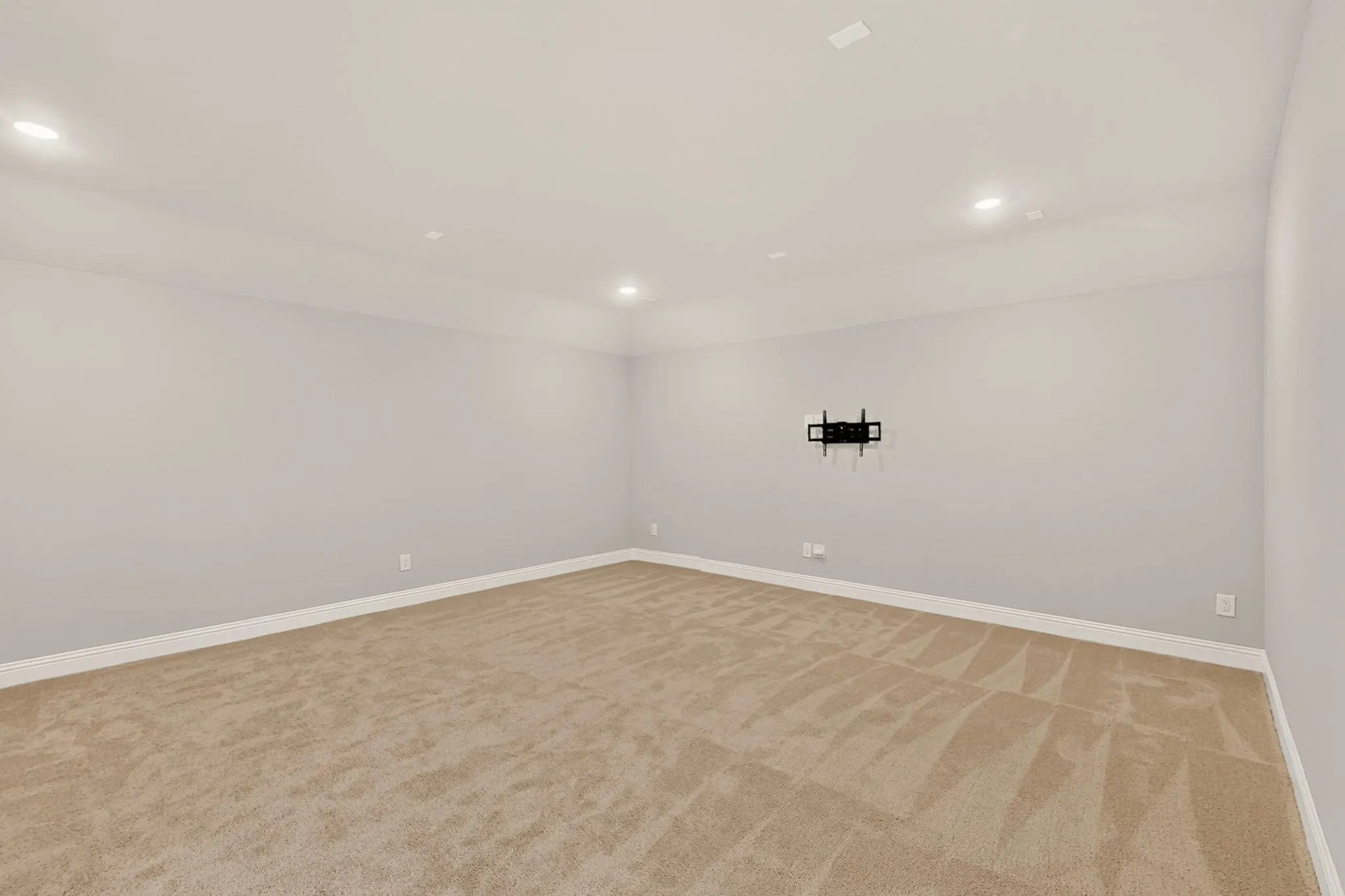 Recessed ceiling lighting, light-colored walls, and neutral carpet flooring