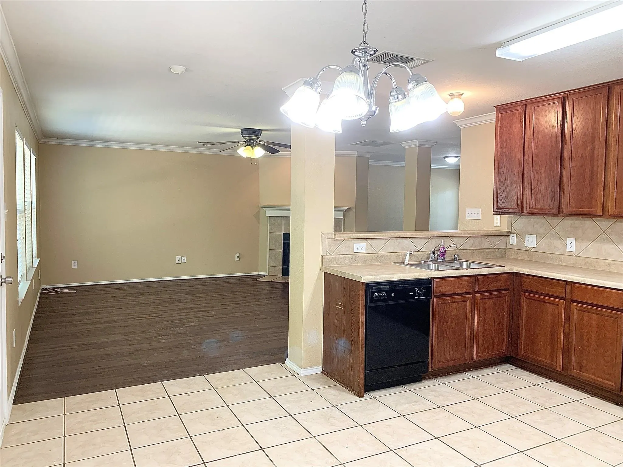 Kitchen featuring wood-finish cabinetry, tile flooring, and a built-in dishwasher