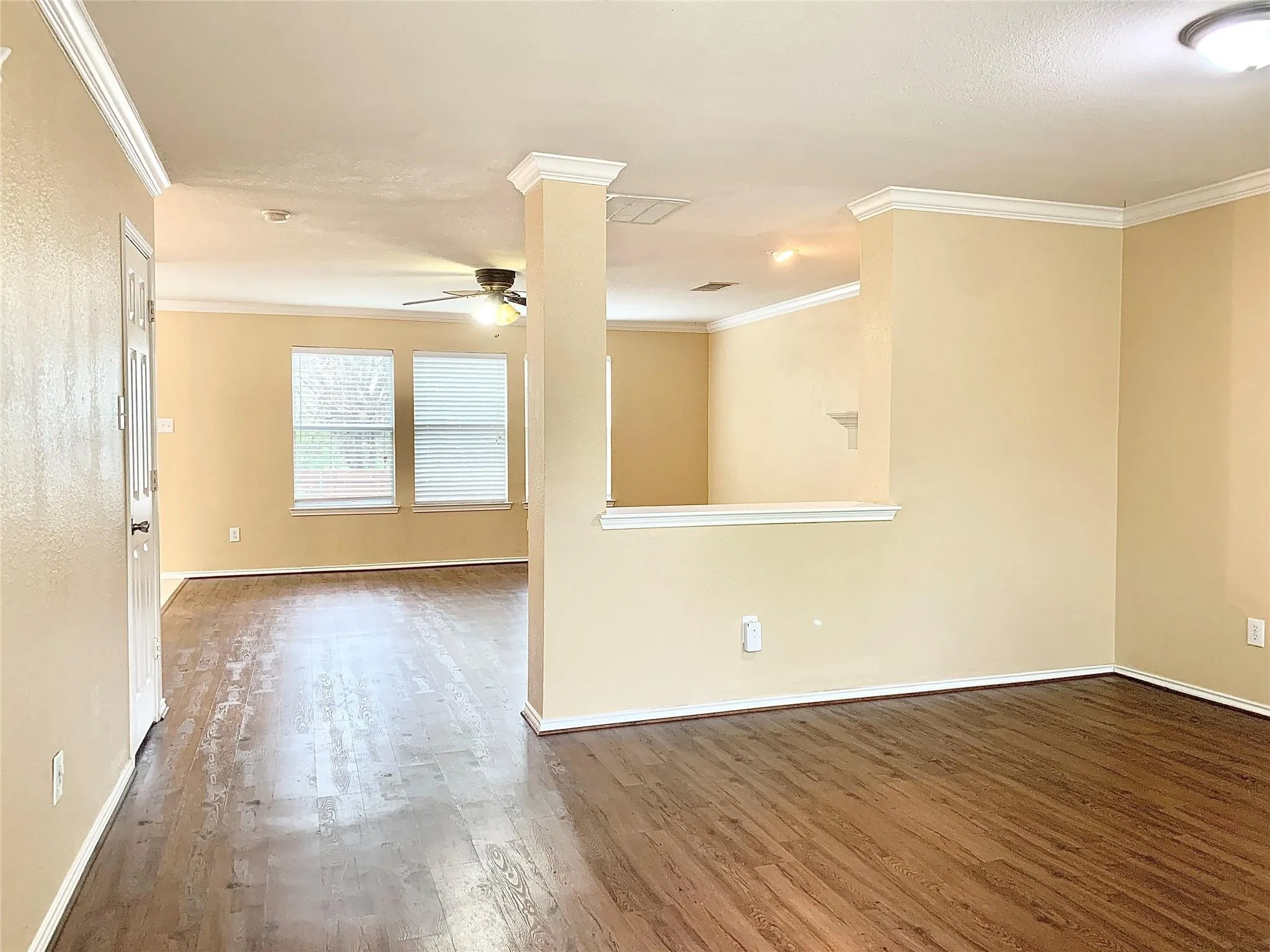 Wood-finish flooring throughout, crown molding, and neutral wall tones