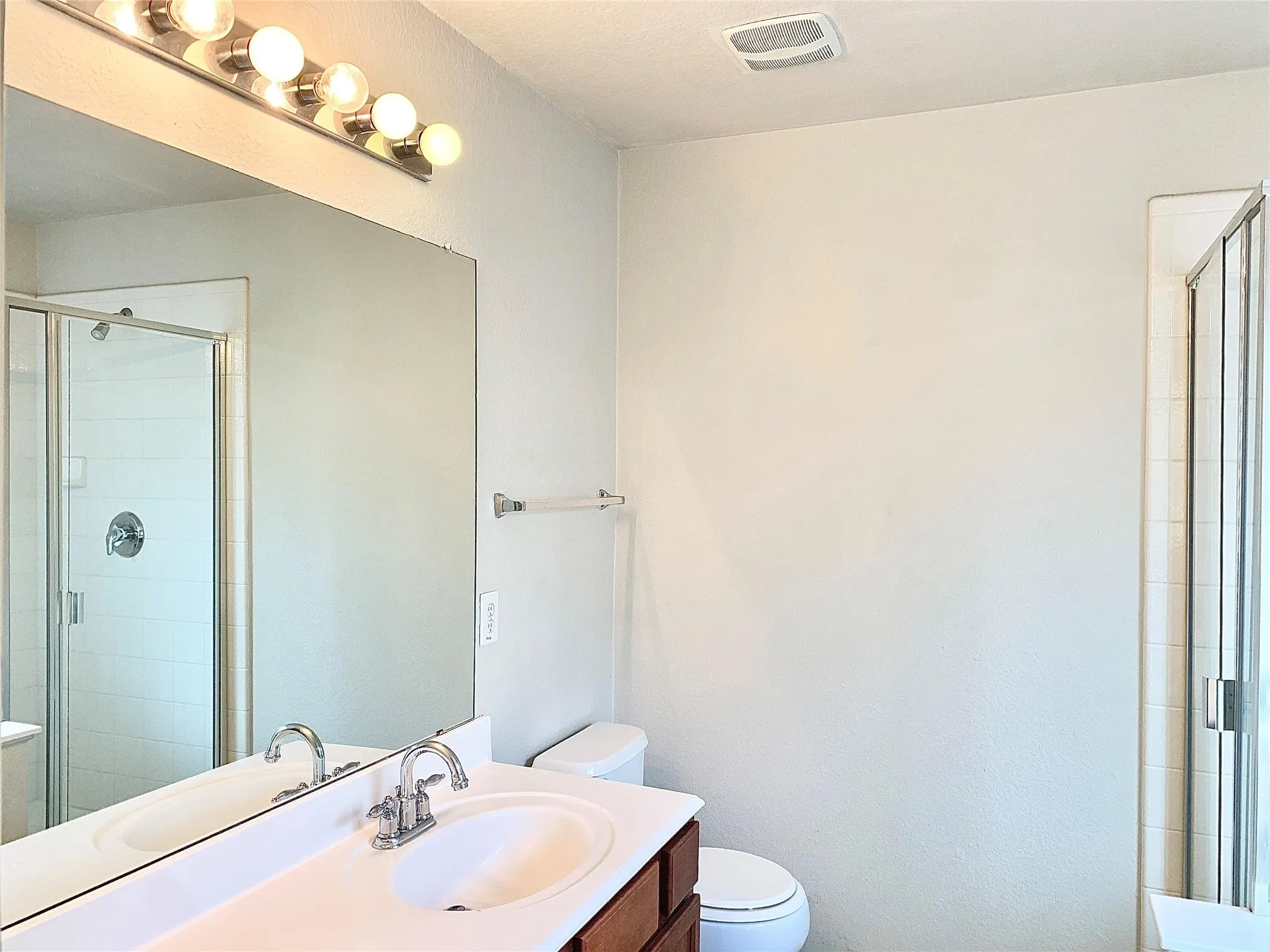 Vanity with an integrated sink, polished chrome faucet, and wood-finish cabinetry