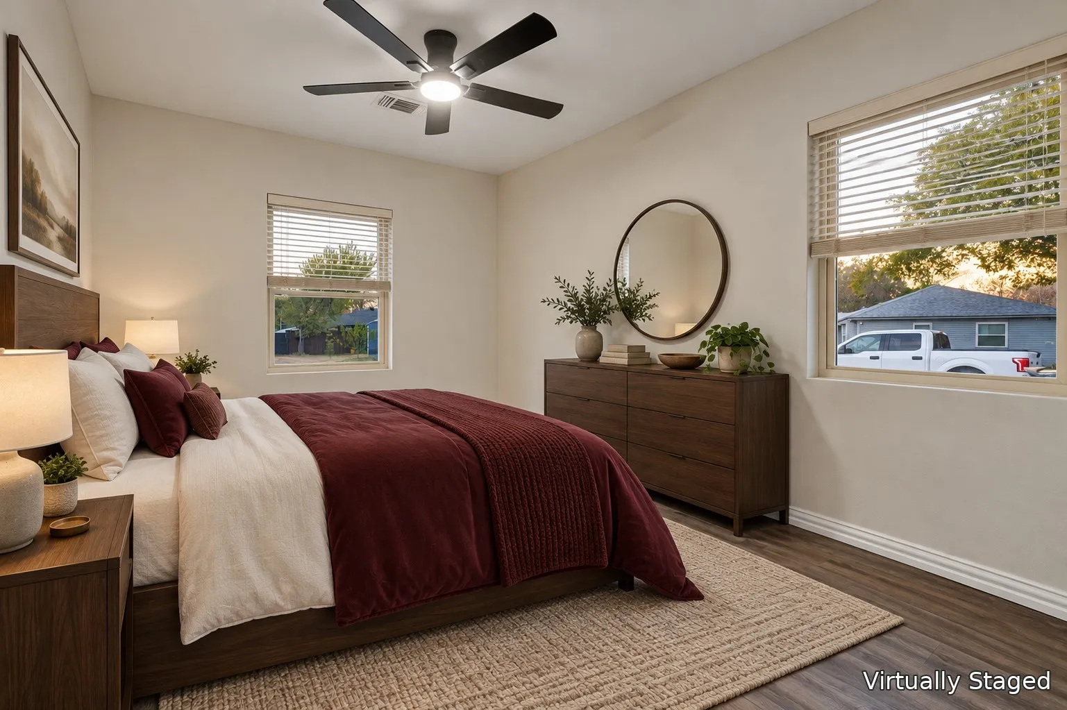 Neutral wall color, wood-finish flooring, two windows, and a ceiling fan with integrated lighting