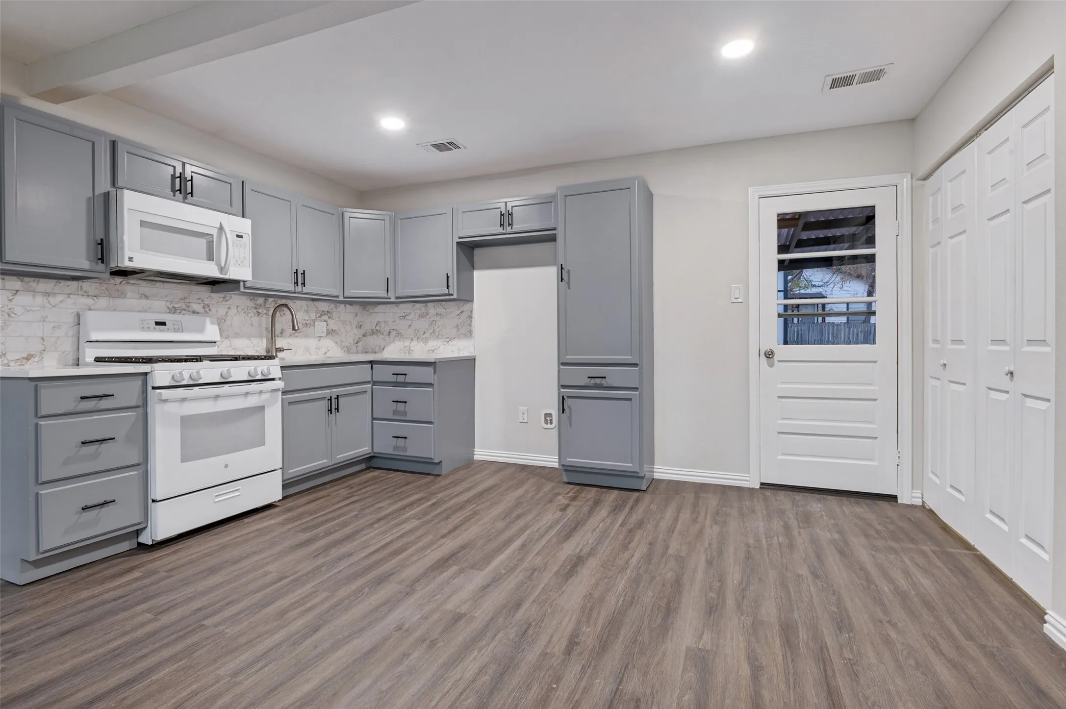 Kitchen featuring gray cabinetry, white countertops, white range, wood-finish flooring, and recessed lighting