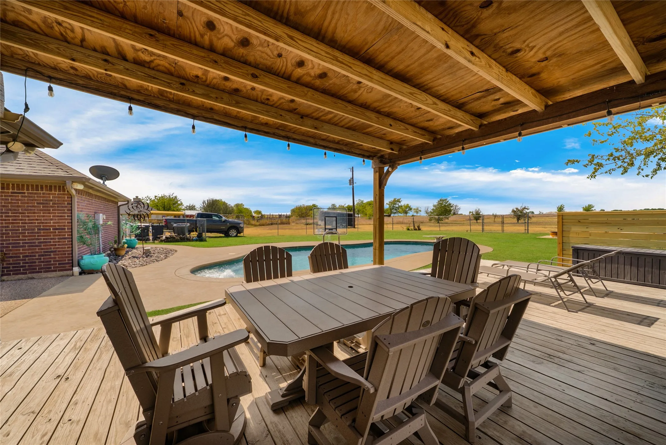 Covered outdoor patio with wood decking and exposed wood ceiling beams