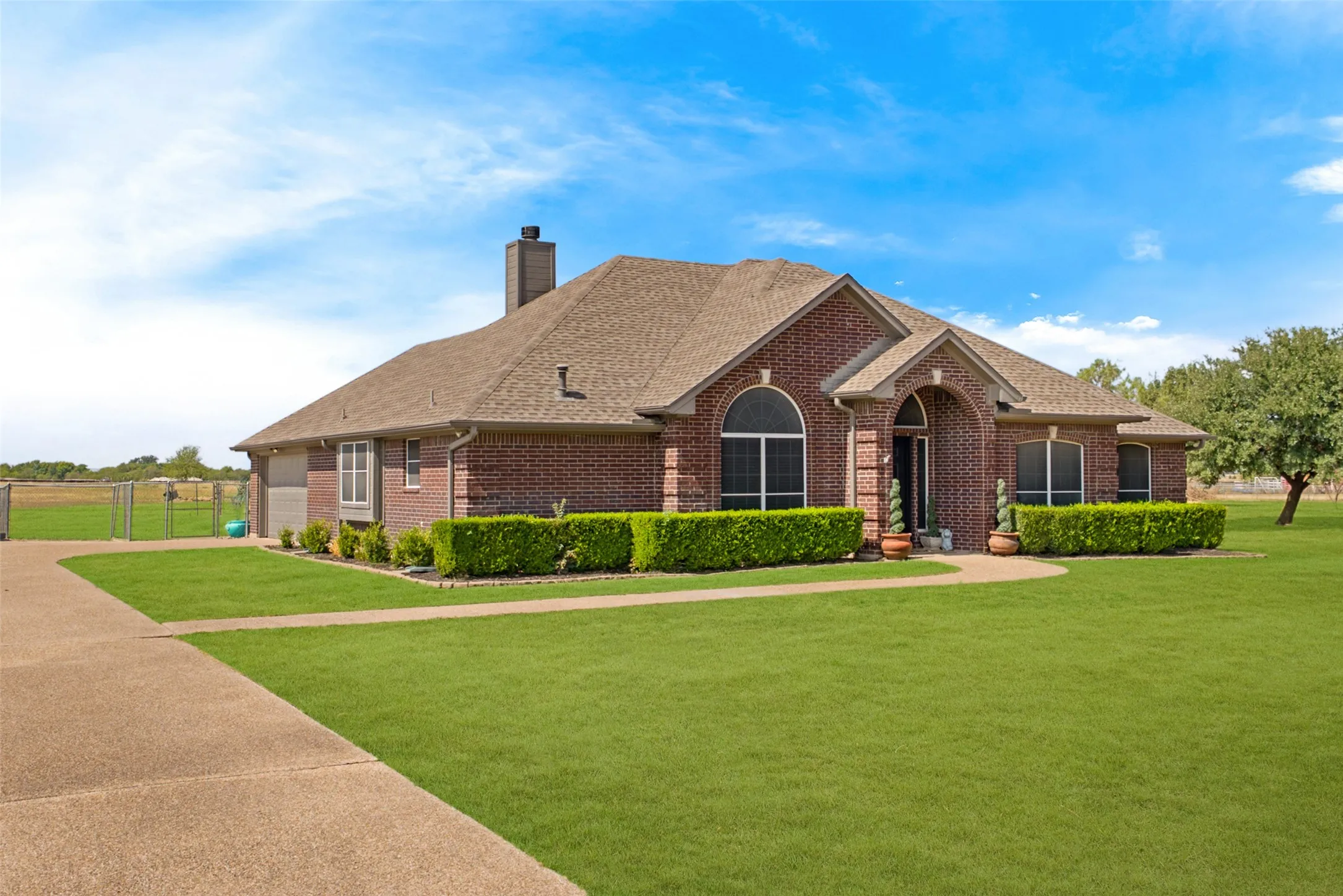 Brick exterior featuring an arched entry, prominent chimney, and a bay window