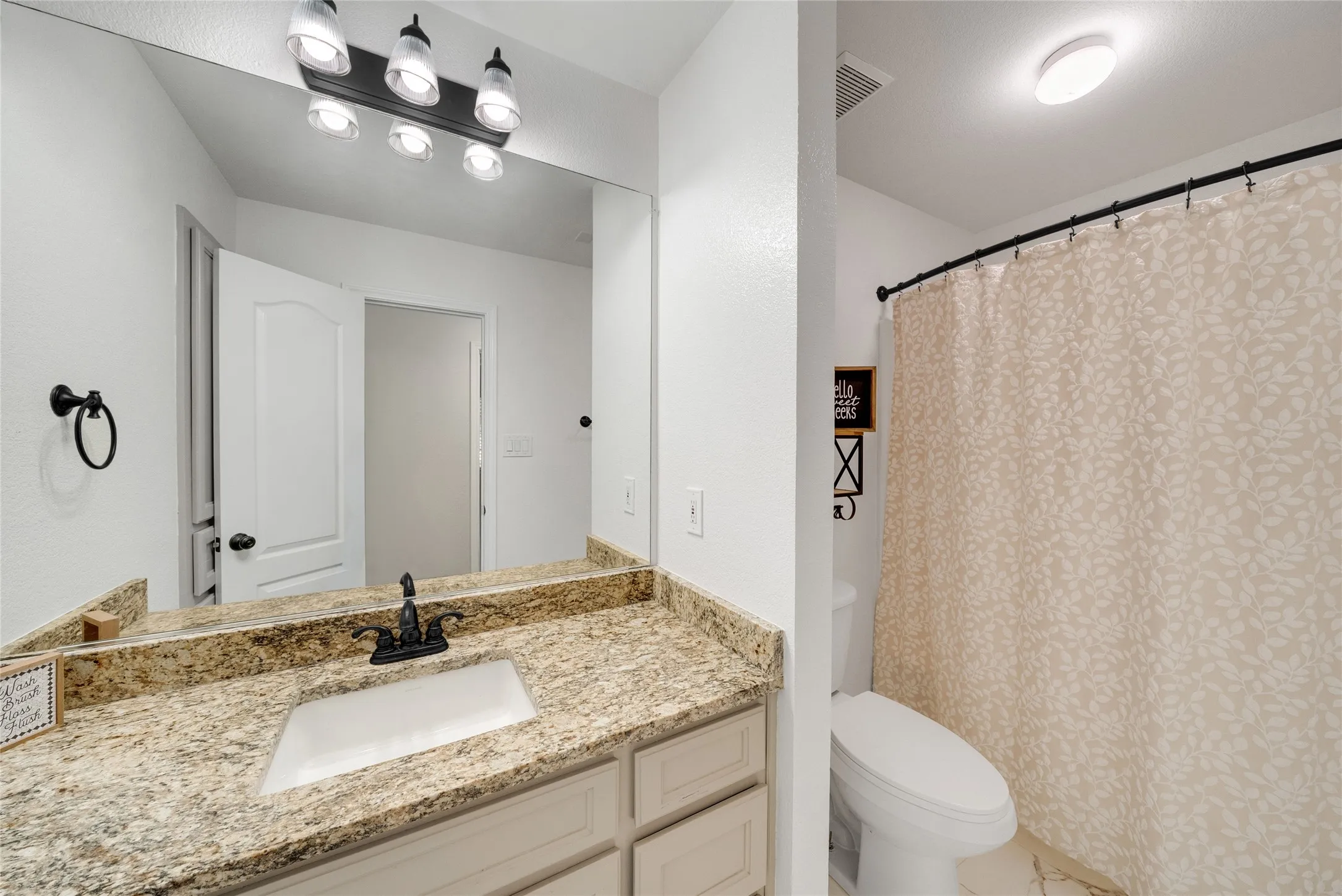 Vanity featuring a stone countertop, an integrated sink, and an oil-rubbed bronze faucet