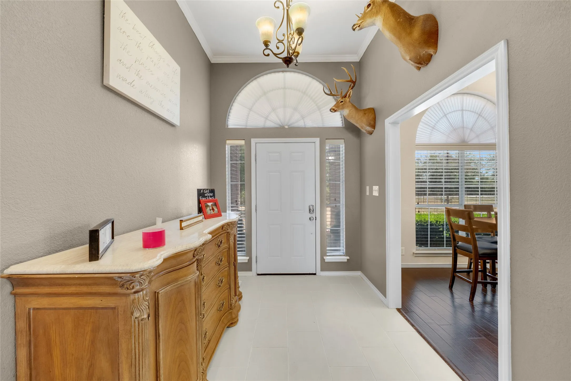 Entryway featuring a white door, sidelight windows, and an arched transom window