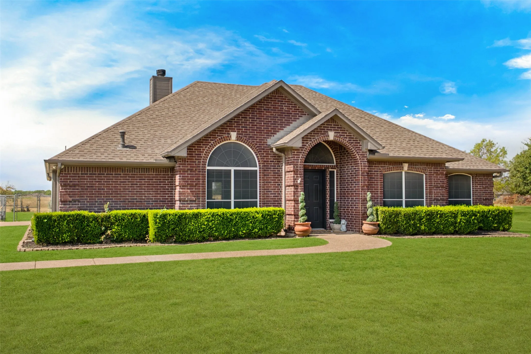 Brick exterior with a gabled roof and arched entry