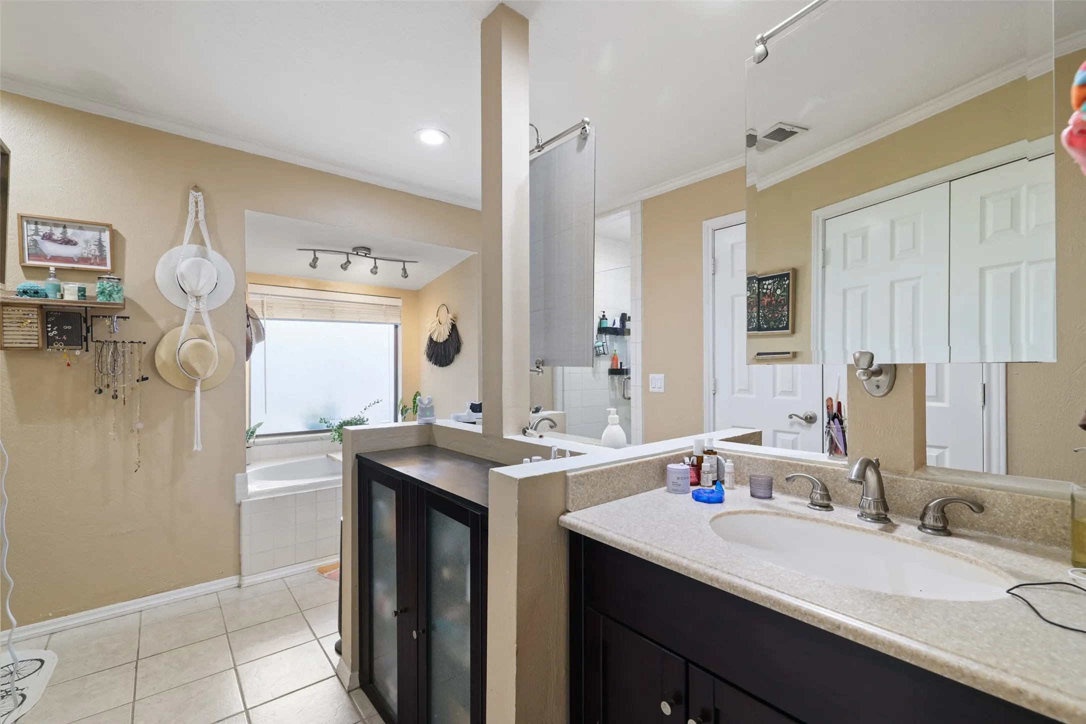 Recessed lighting, tile flooring, built-in bathtub, dual vanity, and frosted window