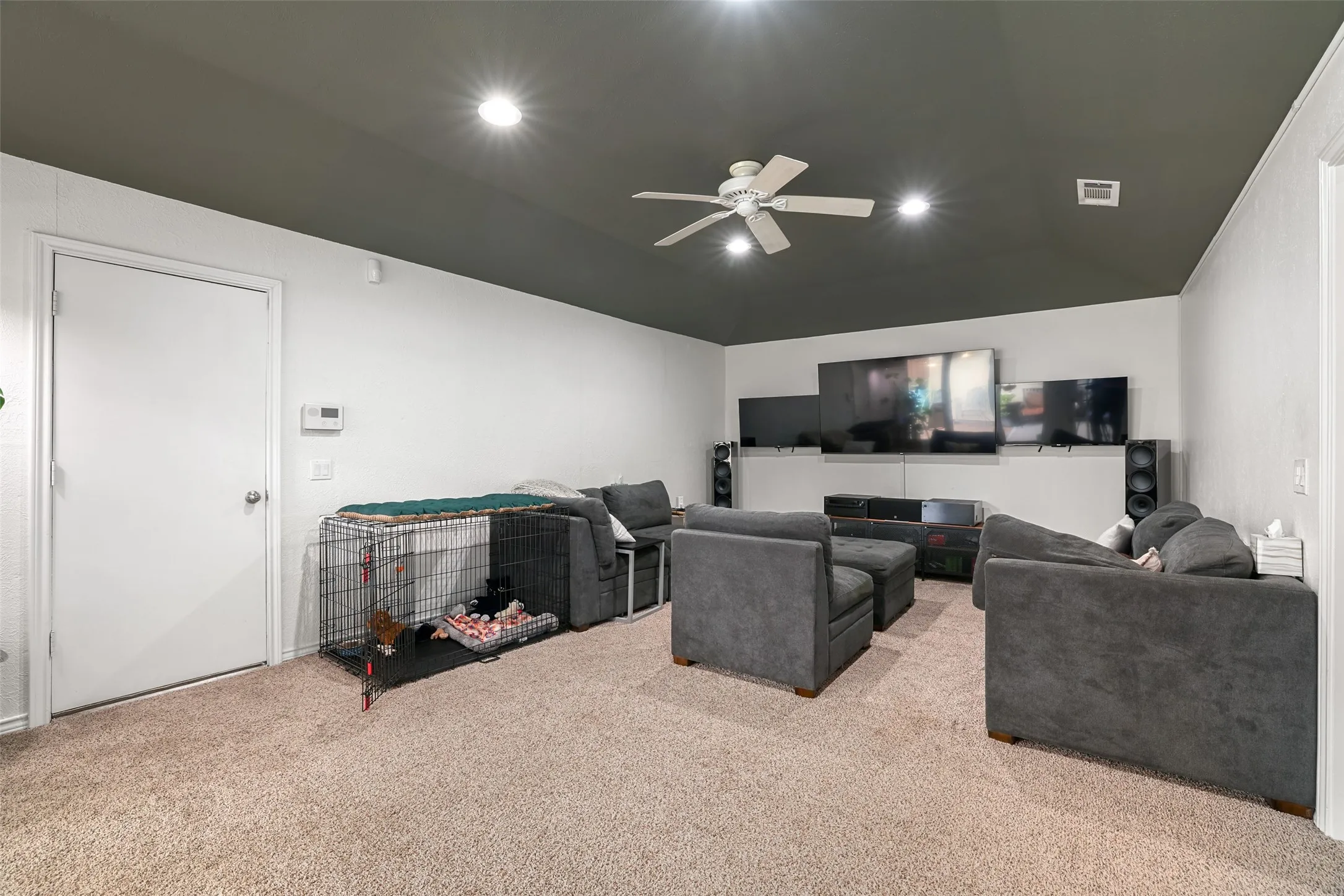 Carpeted living space featuring a ceiling fan, recessed lighting, and a neutral color palette