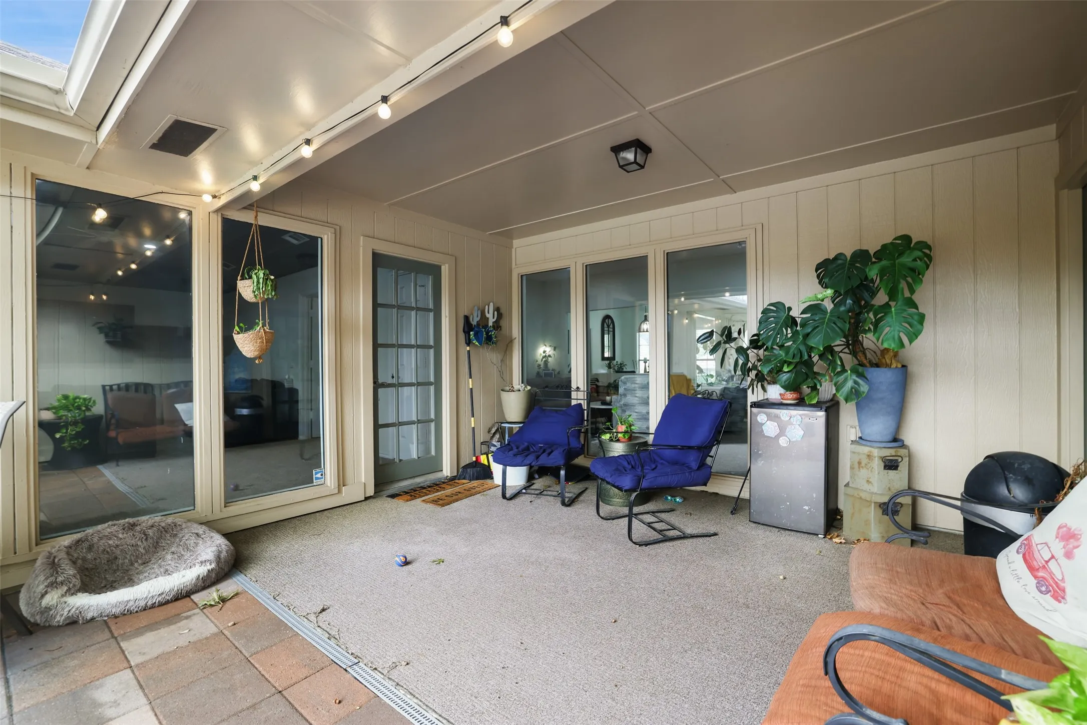 Covered patio featuring a ceiling fan, recessed lighting, string lights, a full-light panel door, and a glass-paneled door