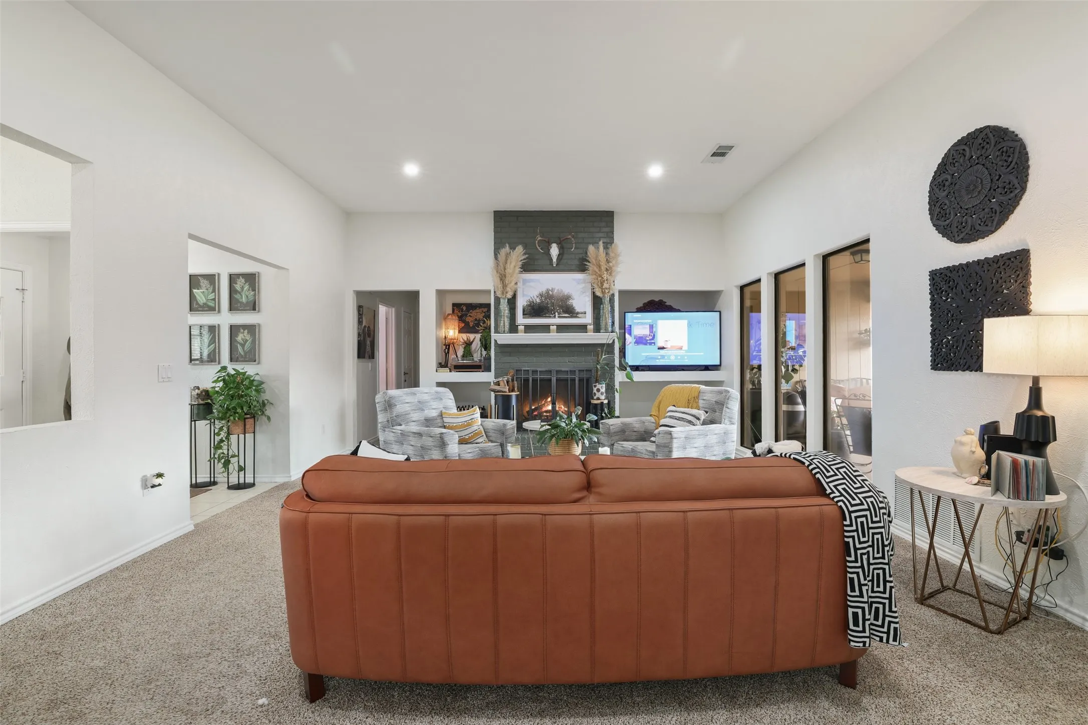 Living area featuring a textured fireplace surround, recessed lighting, and integrated​​‌​​​​‌​​‌‌​‌‌​​​‌‌​‌​‌​‌​​​‌​​ shelving