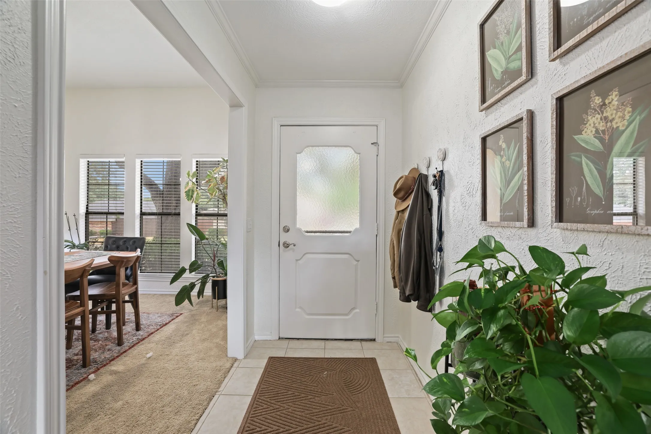 Entryway featuring a paneled door with frosted glass, ceramic tile flooring, and textured wall finish