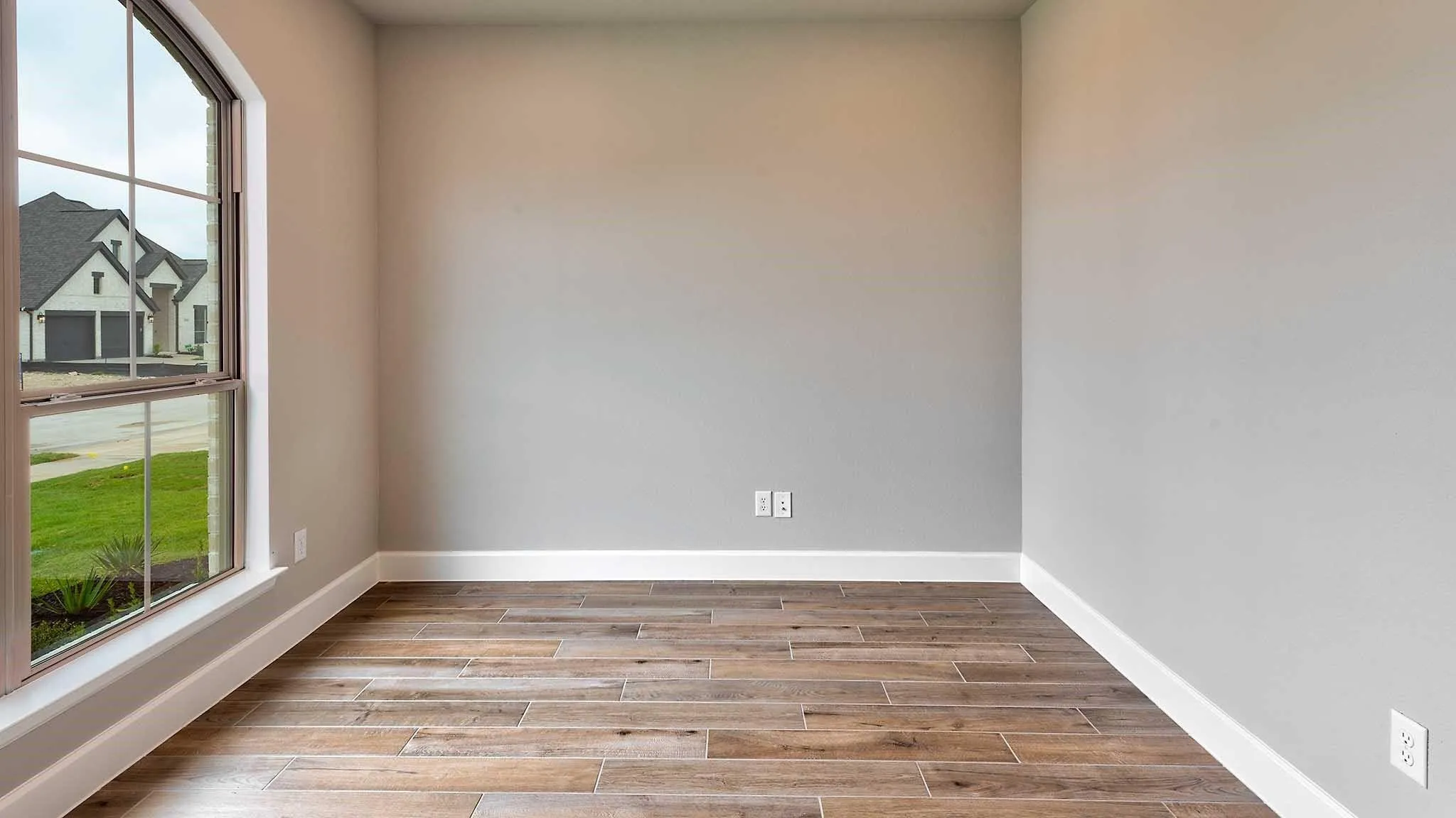 Wood-finish flooring, neutral wall tones, and white trim
