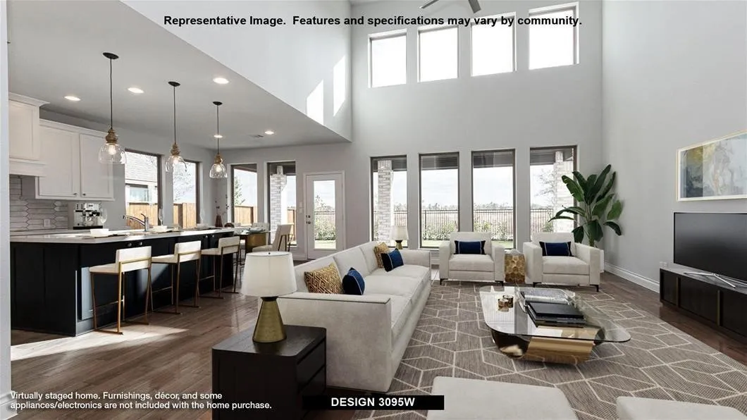 Double-height ceiling, wood-finish flooring, recessed lighting, expansive windows, and an open-concept kitchen with an island