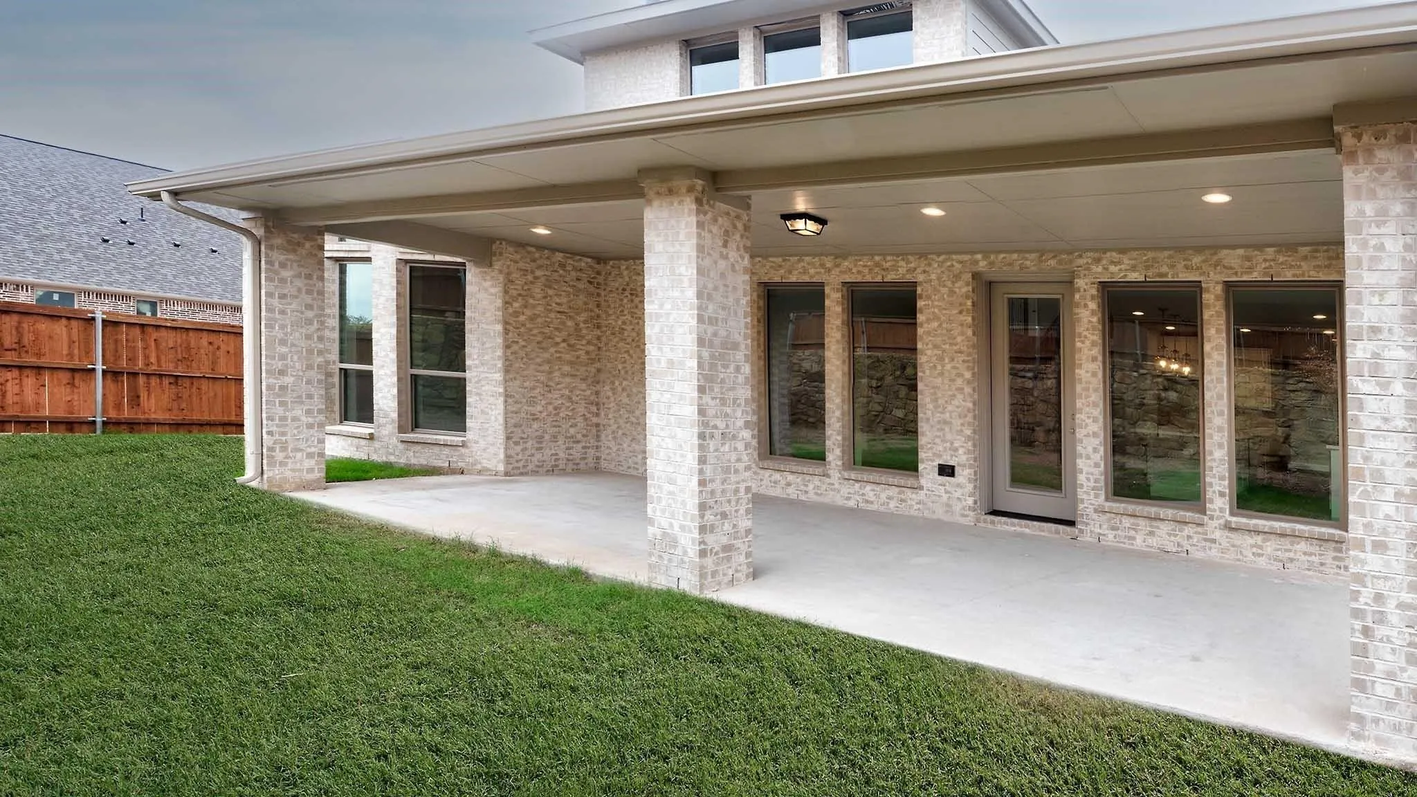 Covered concrete patio with recessed lighting and a ceiling-mounted fixture