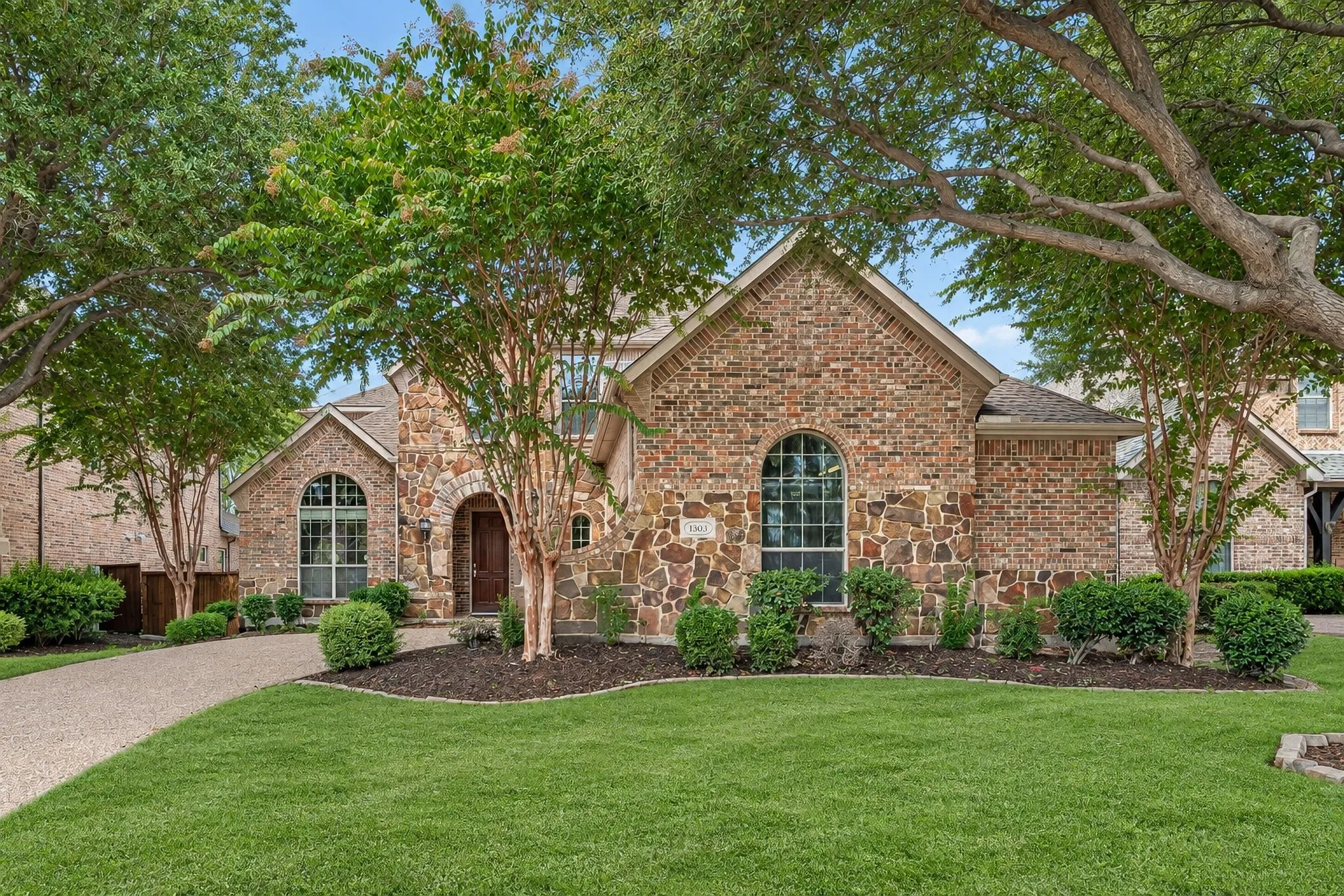 Straight-On Front Photo.  Grass Has Been Virtually Greened and Patched Where Missing Grass Is Due To Shade Trees.