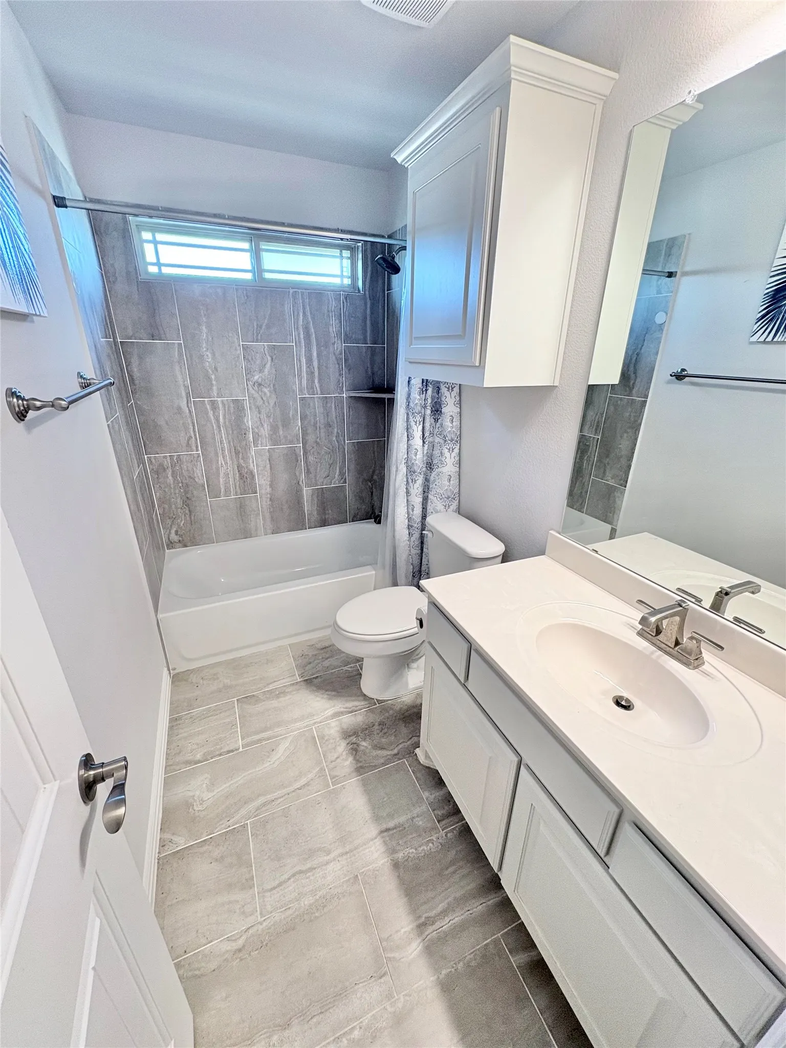 White vanity with an integrated sink, brushed nickel faucet, and a large mirror