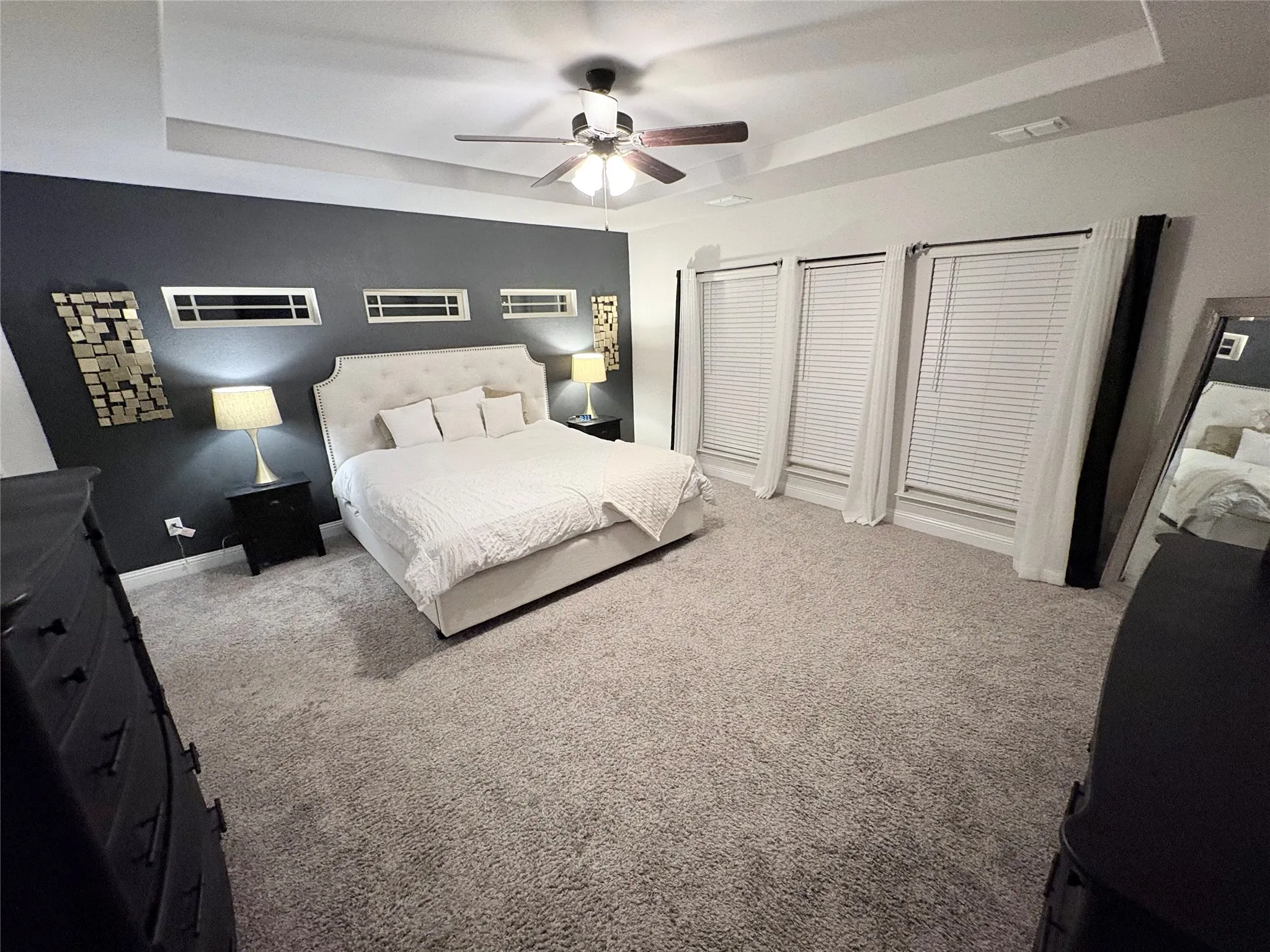 Tray ceiling with a ceiling fan, recessed lighting, and carpeted flooring