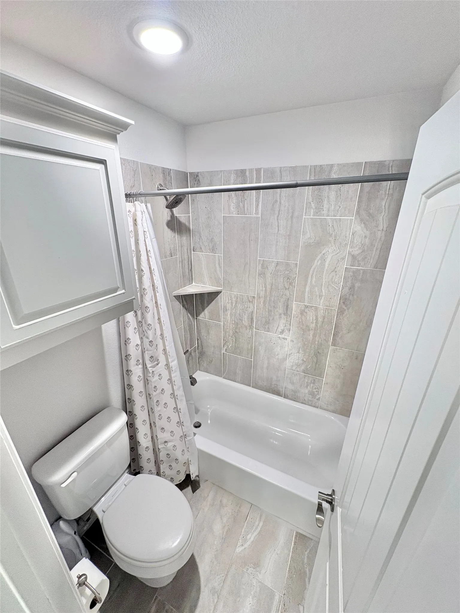 Recessed lighting illuminating a full bathtub and shower combination